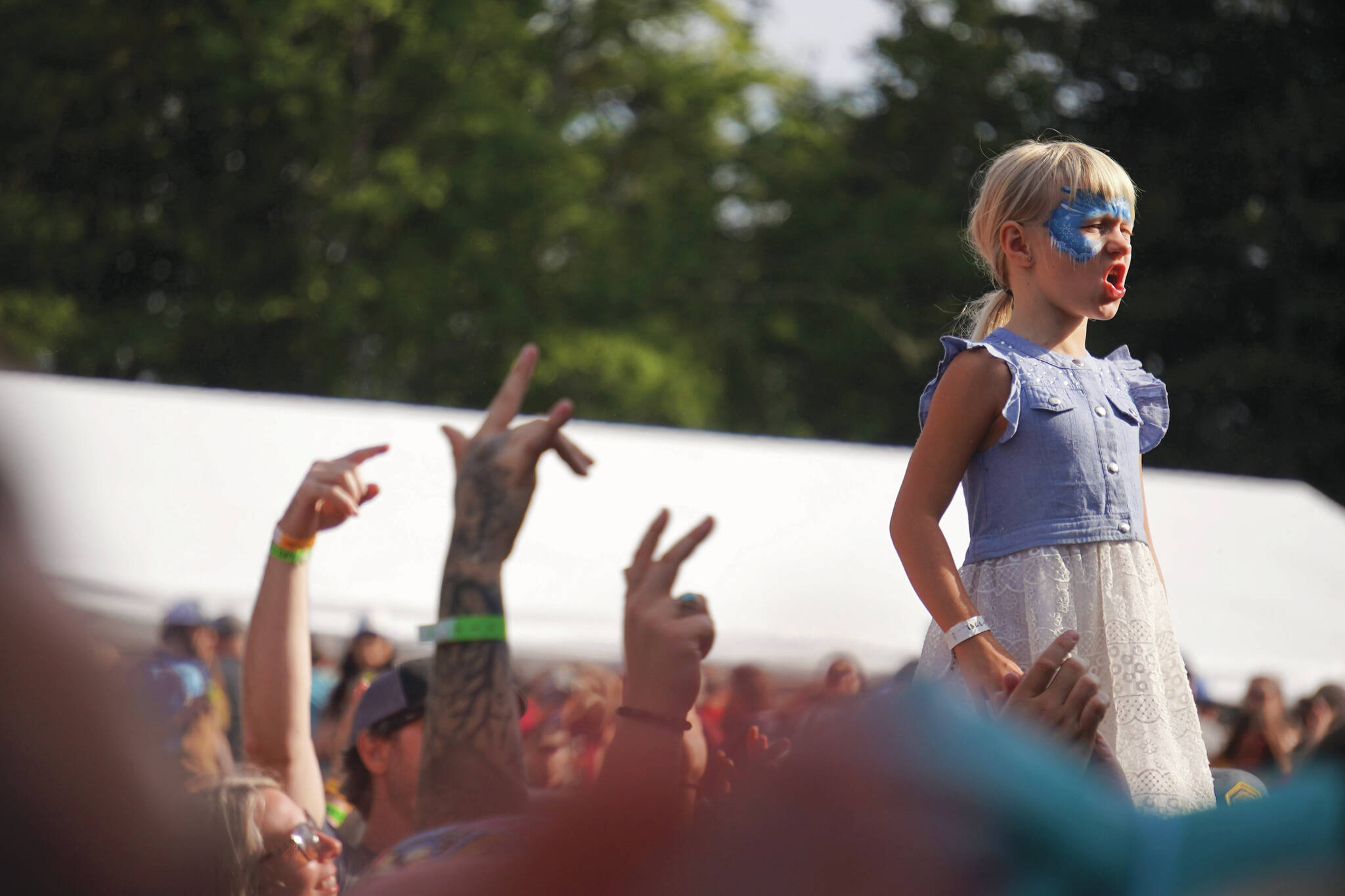 Photos by Jake Dye/Peninsula Clarion
Mynarae Glover stands on her father, James Glover’s shouders during a performance by Medium Build on the River Stage at Salmonfest in Ninilchik, on Friday.