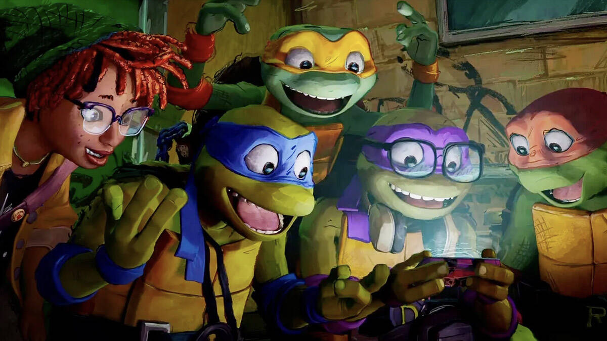 April O’Neil, Leonardo, Michelangelo, Donatello and Raphael gather around a cell phone in “Teenage Mutant Ninja Turtles: Mutant Mayhem.” (Photo courtesy Paramount)