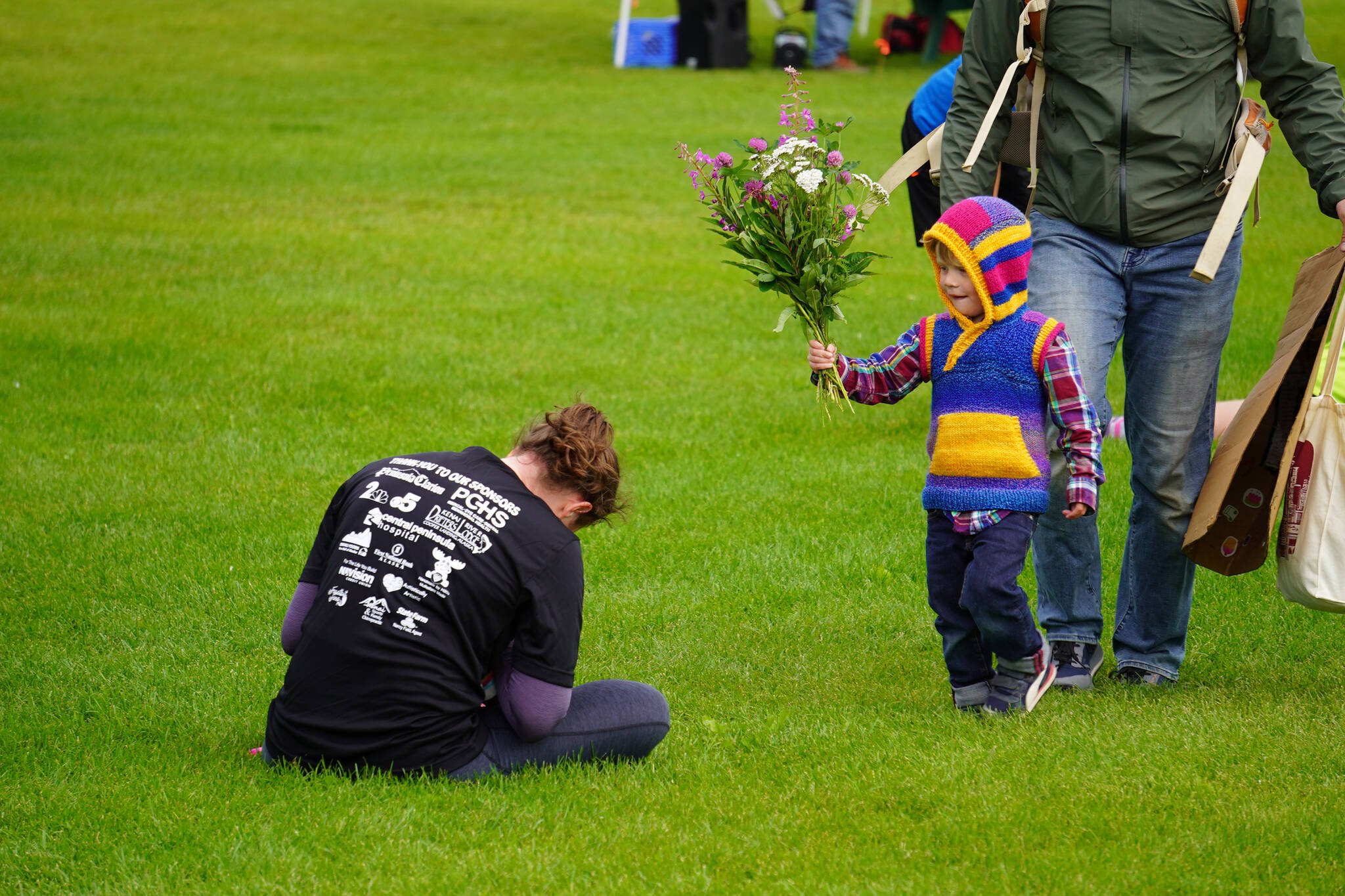 Mollie Messick receives flowers from her child after finishing the 34th Annual Kenai Peninsula Violence Free Community Run in Kenai, Alaska, on Saturday, Aug. 12, 2023. (Jake Dye/Peninsula Clarion)