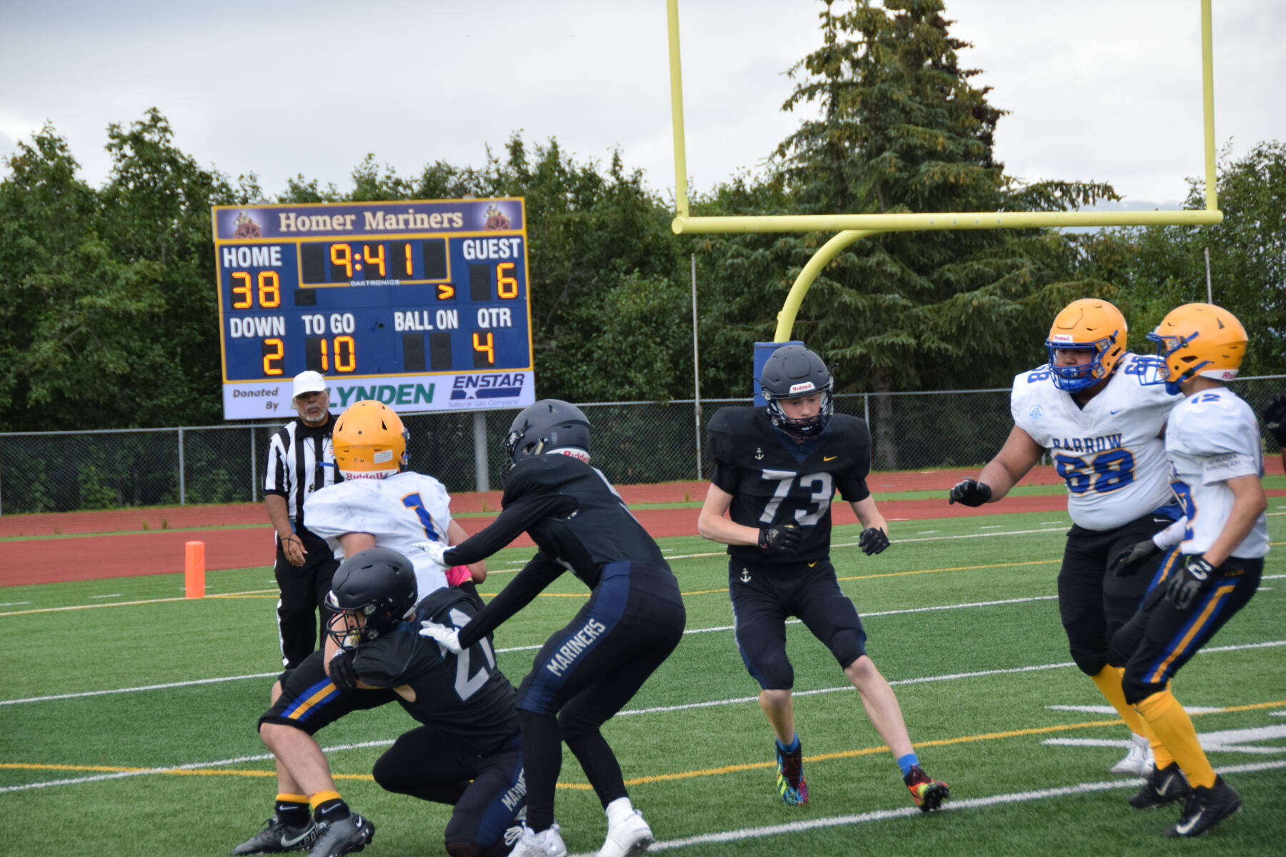 Barrow’s Angelo Reyes carries the ball but is tackled by Homer in the fourth quarter of the home opener game on Saturday, Aug. 12, 2023 in Homer, Alaska. (Delcenia Cosman/Homer News)