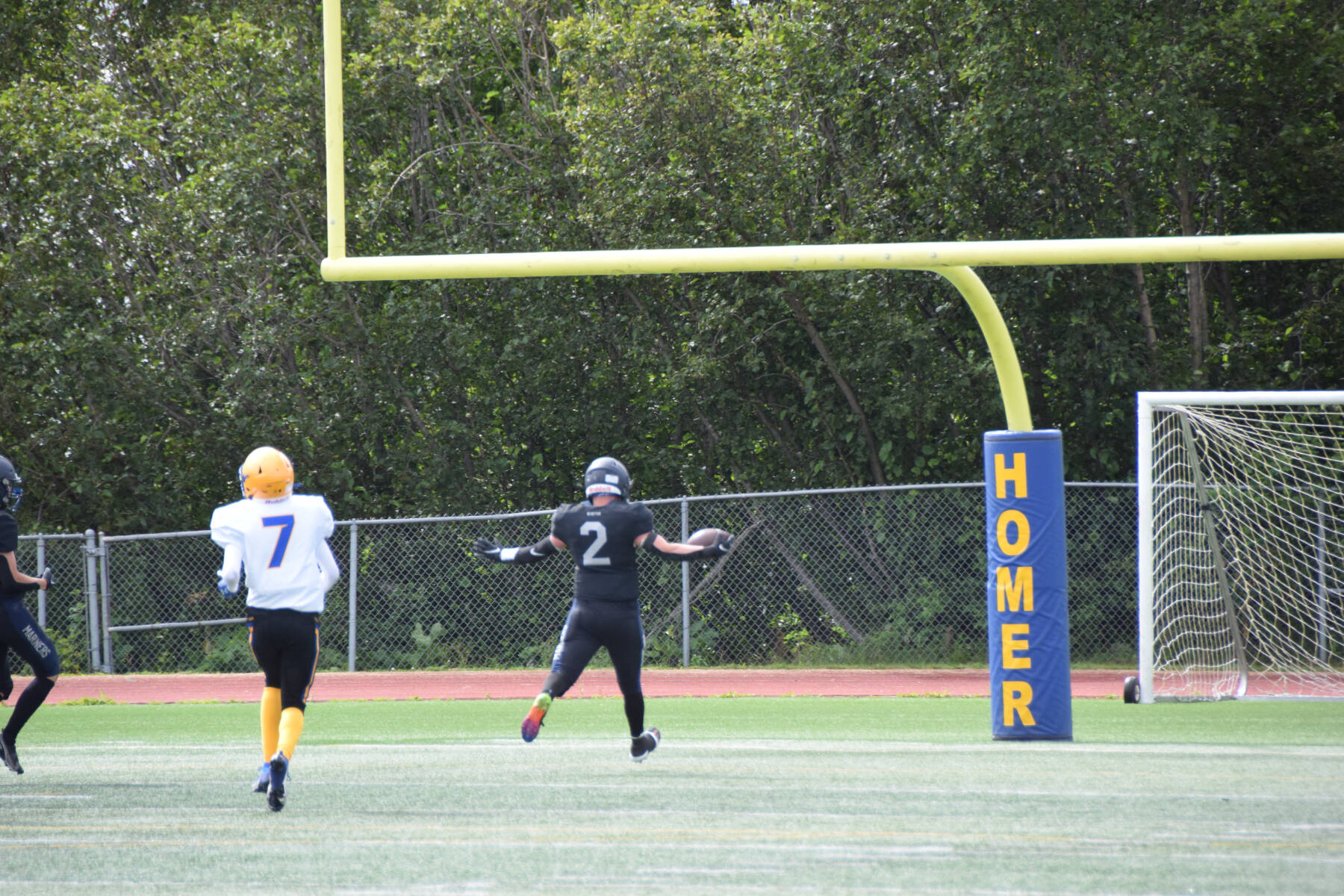 Homer’s Chris Martishev catches a 58-yard pass from quarterback Preston Stanislaw, scoring a touchdown and bringing the Mariners’ score up to eight points in the first quarter of the home opener varsity game on Saturday, Aug. 12, 2023 in Homer, Alaska. (Delcenia Cosman/Homer News)