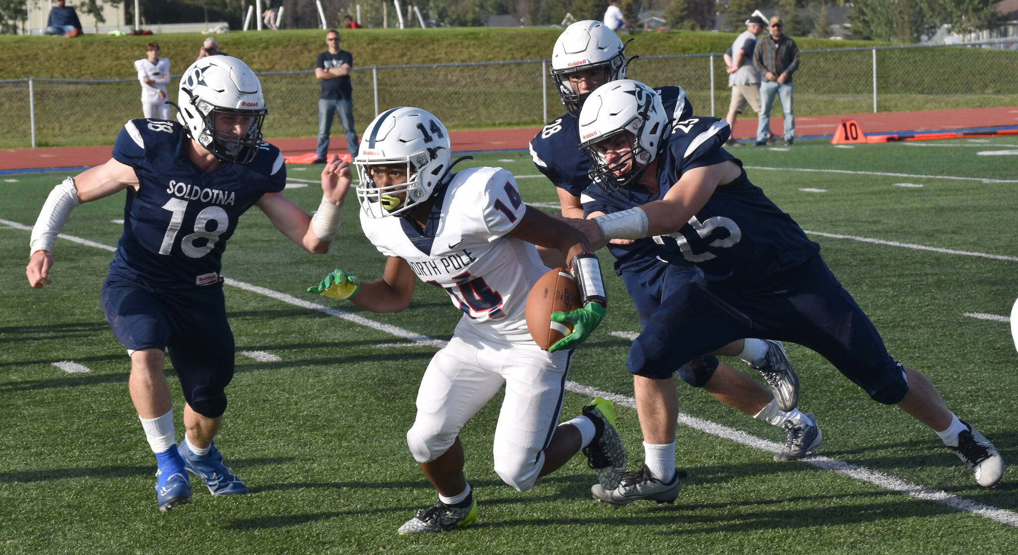 Soldotna’s Collin Peck and Gehret Medcoff track down North Pole’s Devon Cooper-Jackson on Friday, Aug. 18, 2023, at Justin Maile Field at Soldotna High School in Soldotna, Alaska. (Photo by Jeff Helminiak/Peninsula Clarion)