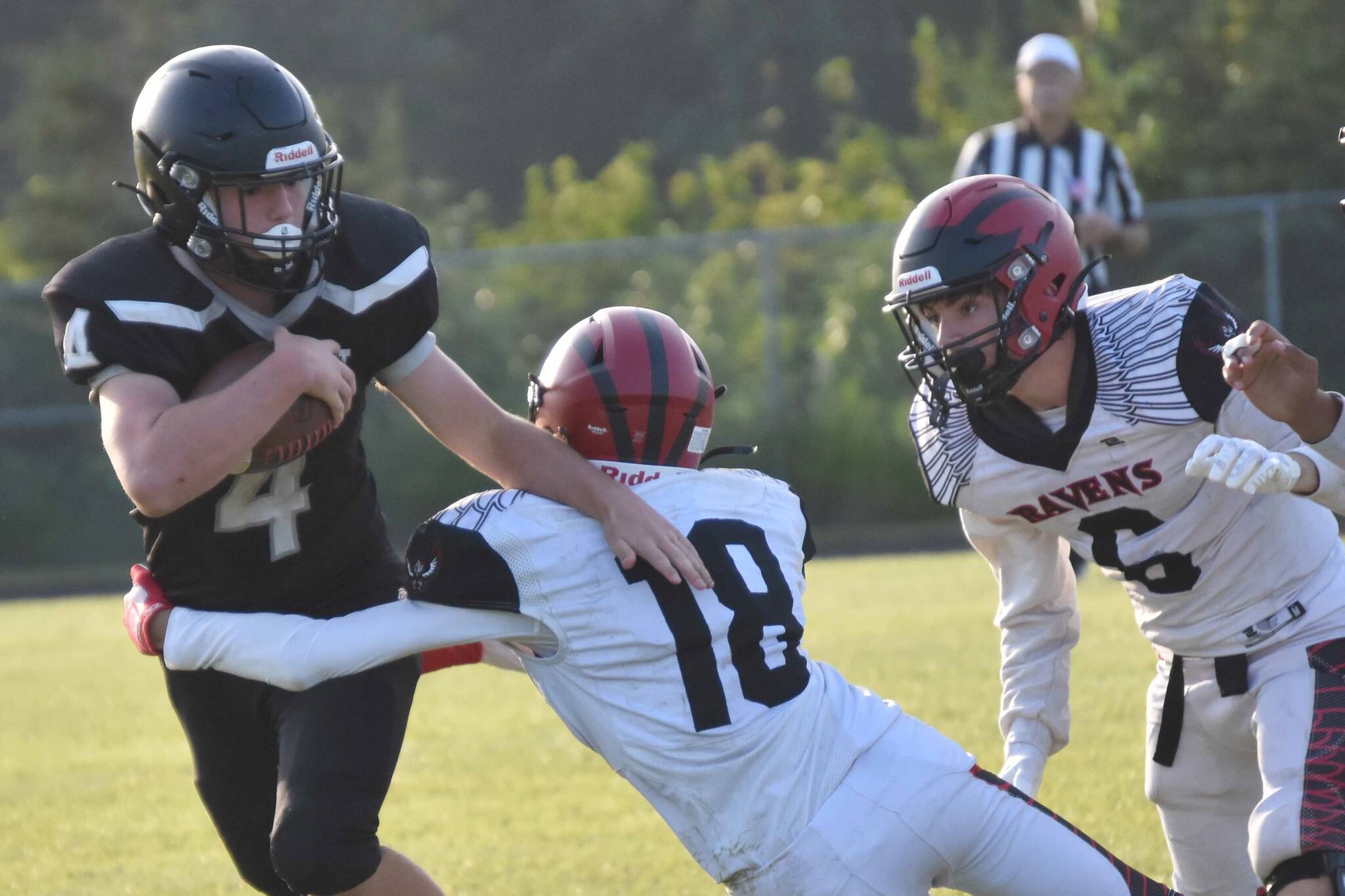 Nikiski's Cameron Parrish tries to shake the tackle of Eielson's Michael Garza on Saturday, Aug. 19, 2023, at Nikiski Middle-High School in Nikiski, Alaska. (Photo by Jeff Helminiak/Peninsula Clarion)