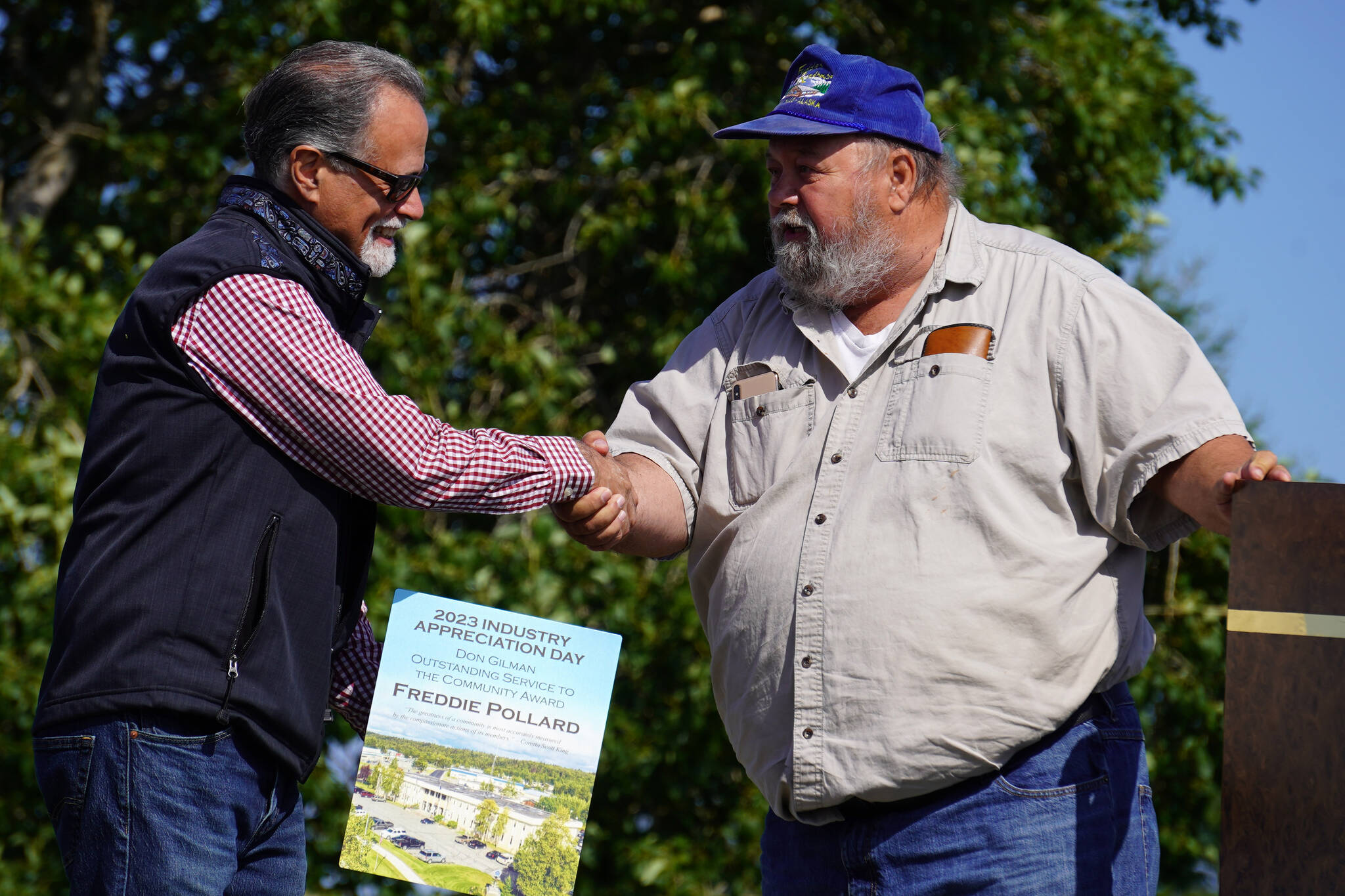 Freddie Pollard Sr., right, receives the Don Gilman Outstanding Service to the Community Award from Kenai Peninsula Borough Mayor Peter Micciche during Industry Appreciation Day festivities at the Kenai softball greenstrip on Saturday, Aug. 19, 2023. (Jake Dye/Peninsula Clarion)