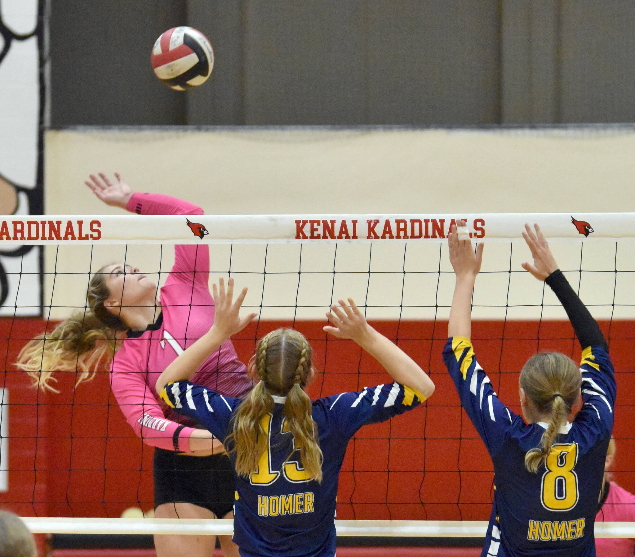 Kenai Central's Emma Beck attacks against Homer's Gracie Miotke and Goldie Hill on Tuesday, Aug. 29, 2023, at Kenai Central High School in Kenai, Alaska. (Photo by Jeff Helminiak/Peninsula Clarion)