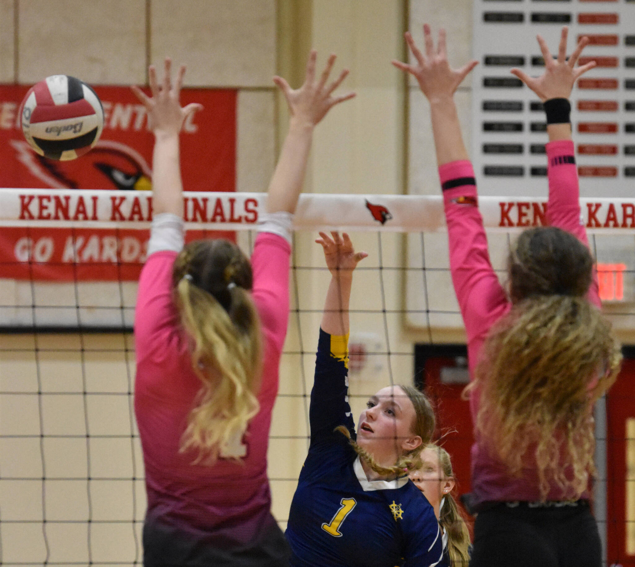 Homer's Channing Lowney attacks against Kenai Central's Avia Miller and Sophie Tapley on Tuesday, Aug. 29, 2023, at Kenai Central High School in Kenai, Alaska. (Photo by Jeff Helminiak/Peninsula Clarion)