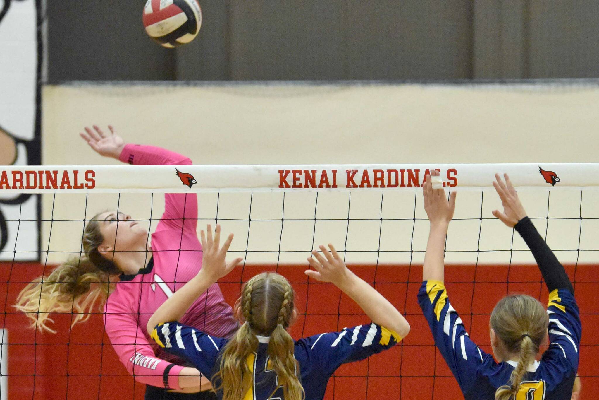 Kenai Central's Emma Beck attacks against Homer's Gracie Miotke and Goldie Hill on Tuesday, Aug. 29, 2023, at Kenai Central High School in Kenai, Alaska. (Photo by Jeff Helminiak/Peninsula Clarion)
