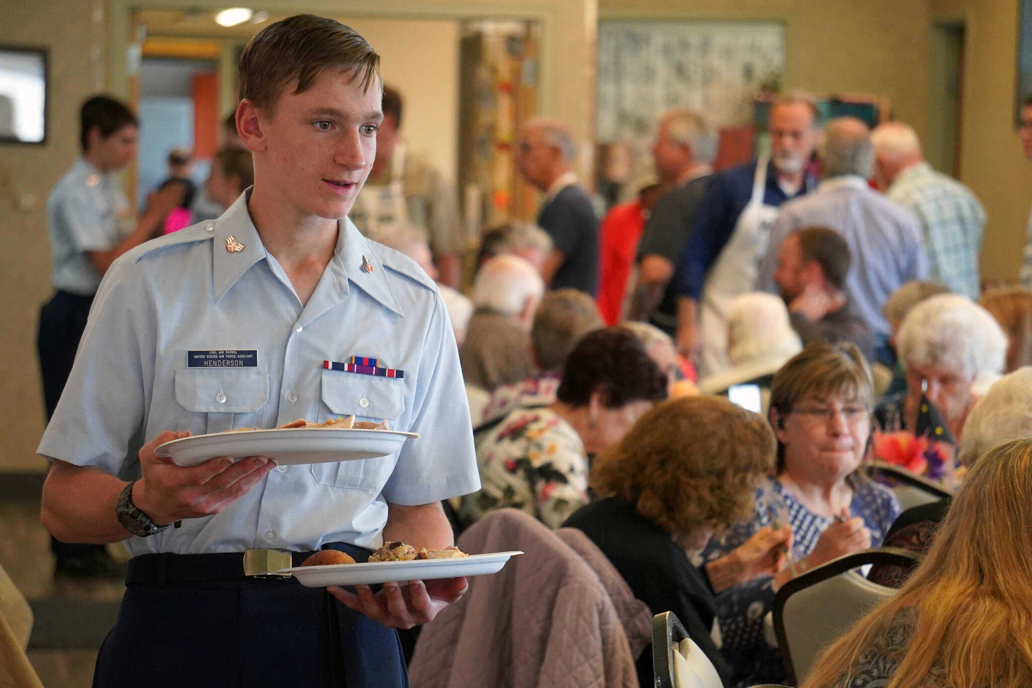 A Civil Air Patrol cadet serves lunch to attendees of the Old Timer’s Luncheon at the Kenai Senior Center in Kenai, Alaska, on Thursday, Aug. 31, 2023. (Jake Dye/Peninsula Clarion)