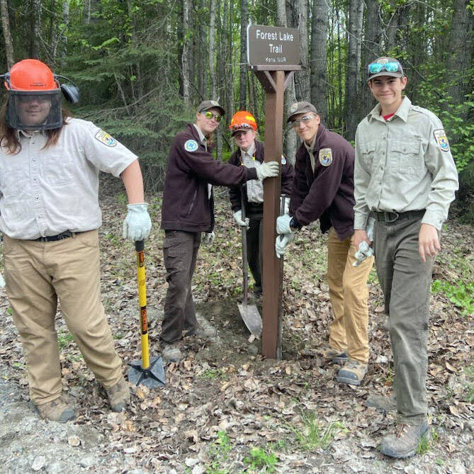 Left to right: Aiden Sullivan, Olivia Somers, Lynnea Hack, Ethan Bowser and Jackson Marion stand proudly next to the installation of a new trailhead sign on Swanson River Road. (Photo by Shea Imgarten)