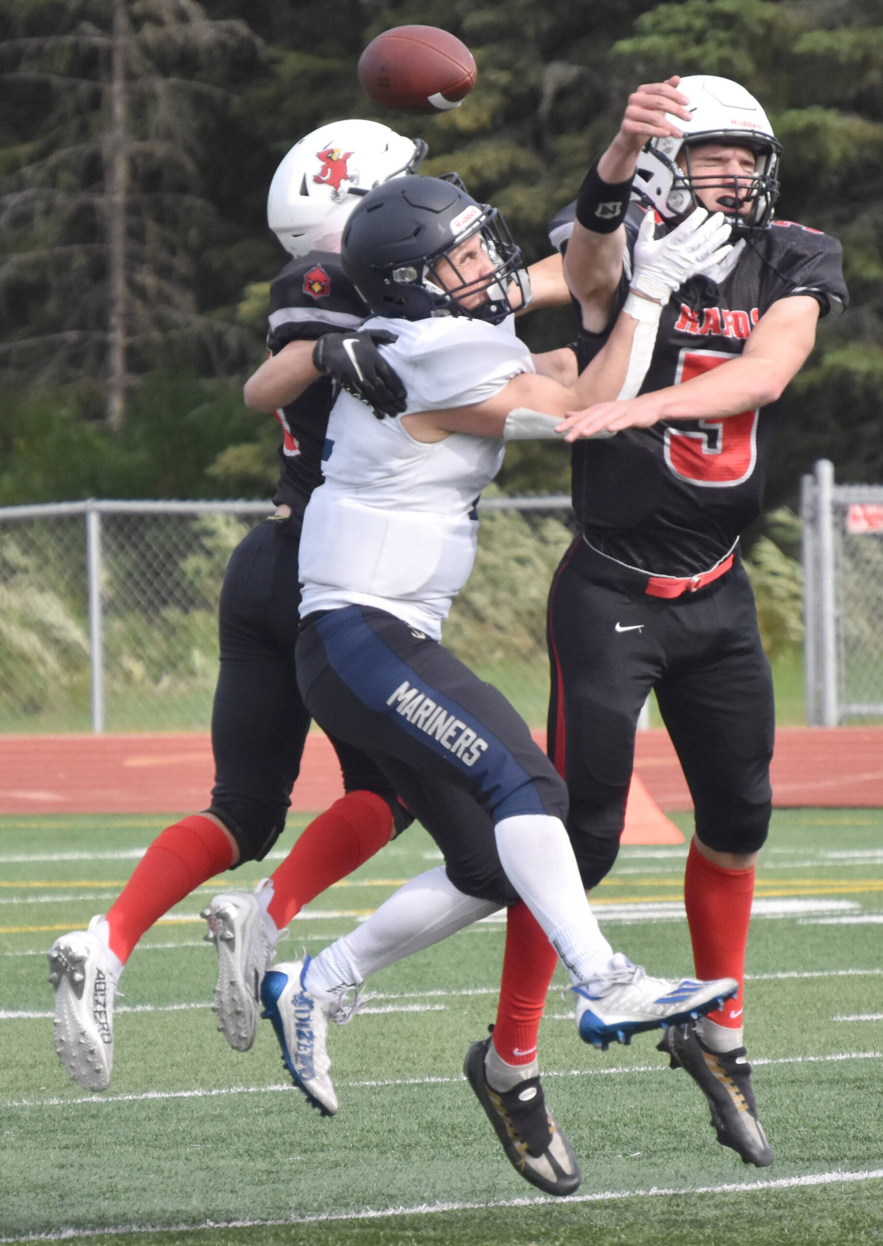 Kenai Central’s Sawyer Vann and Zeke Yragui break up a pass intended for Homer’s Chris Martishev on Saturday, Sept. 2, 2023, at Ed Hollier Field at Kenai Central High School in Kenai, Alaska. (Photo by Jeff Helminiak/Peninsula Clarion)
