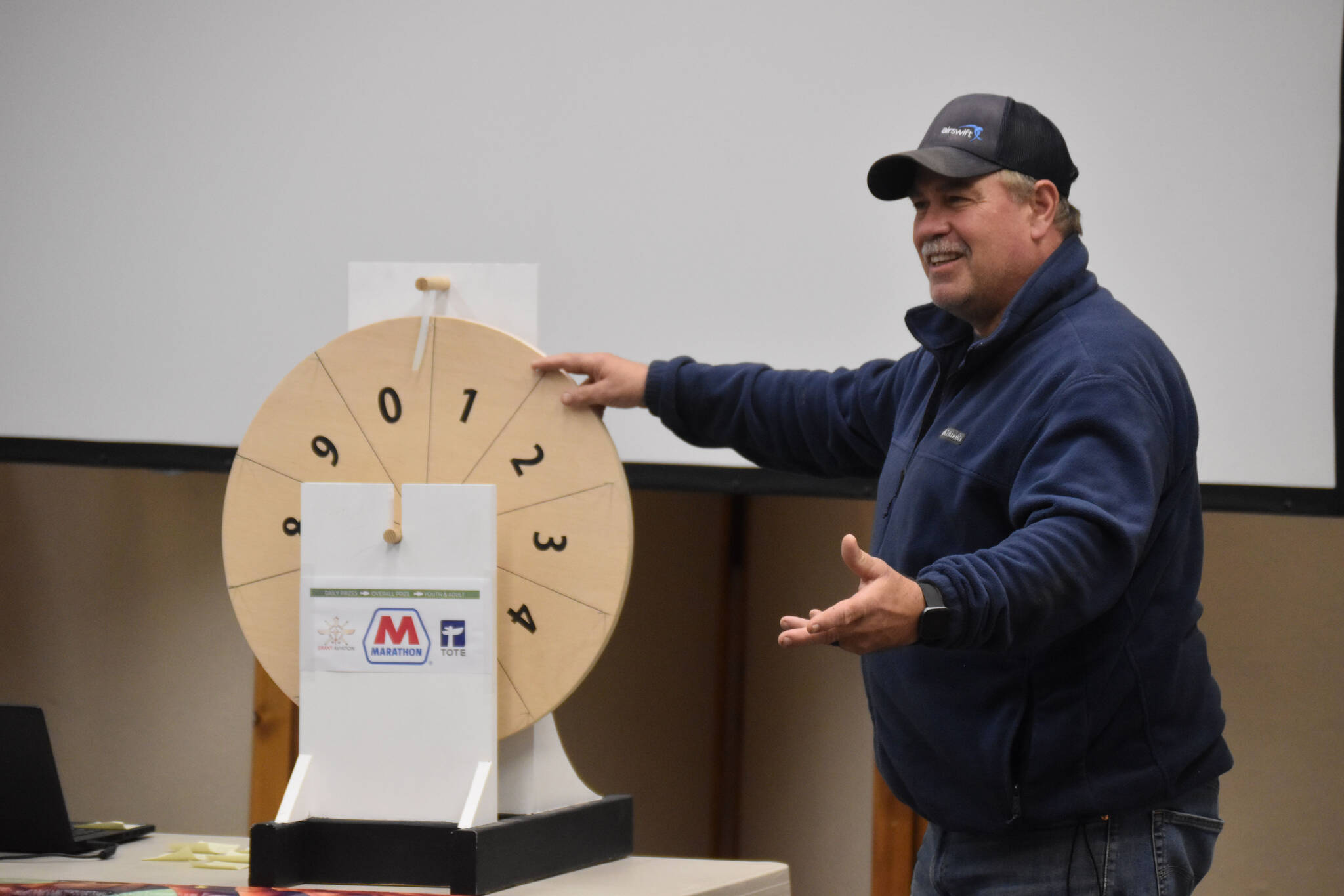 Kenai Mayor Brian Gabriel prepares to spin one of the wheels that determine the magic weight at the closing ceremony of the Kenai Silver Salmon Derby on Monday, Sept. 19, 2022, in Kenai, Alaska. (Jake Dye/Peninsula Clarion)