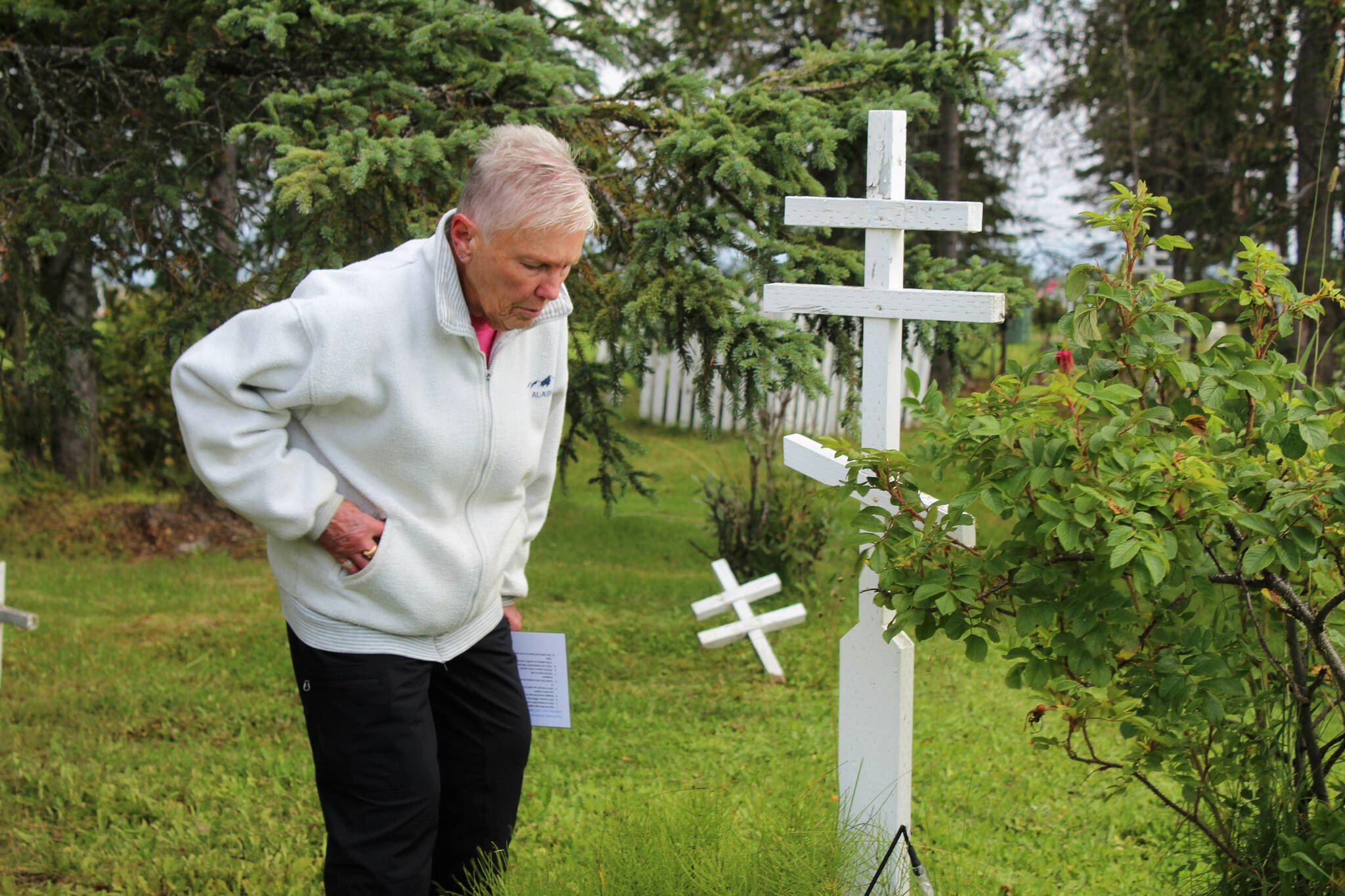 Kenai Historical Society President June Harris inspects a grave marker as part of the City of Kenai’s cemetery imaging project on Friday, Sept. 8, 2023, in Kenai, Alaska. (Ashlyn O’Hara/Peninsula Clarion)