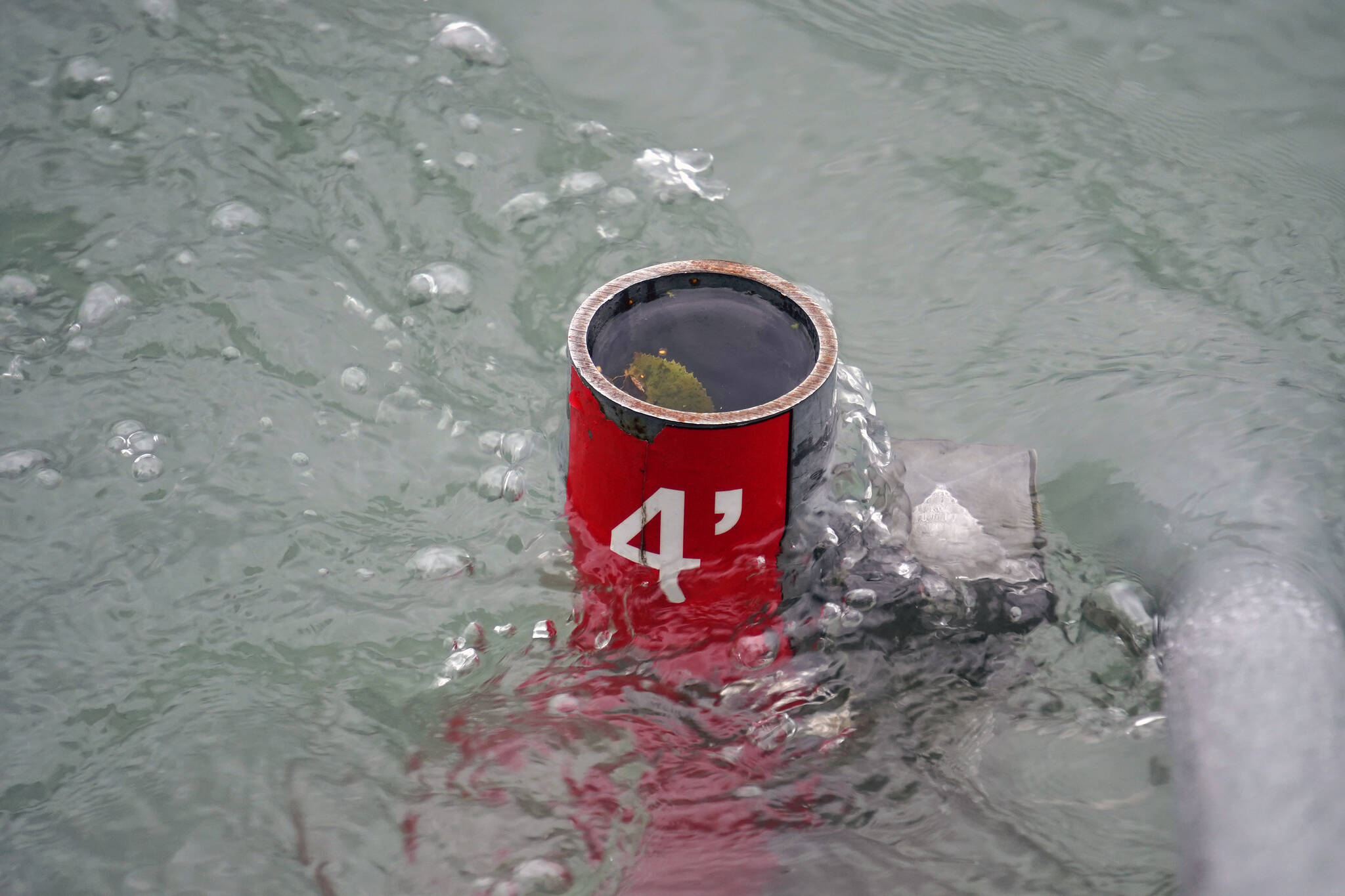 A depth marker is almost entirely subsumed by the waters of the Kenai River in Soldotna, Alaska, on Tuesday, Sept. 12, 2023. (Jake Dye/Peninsula Clarion)