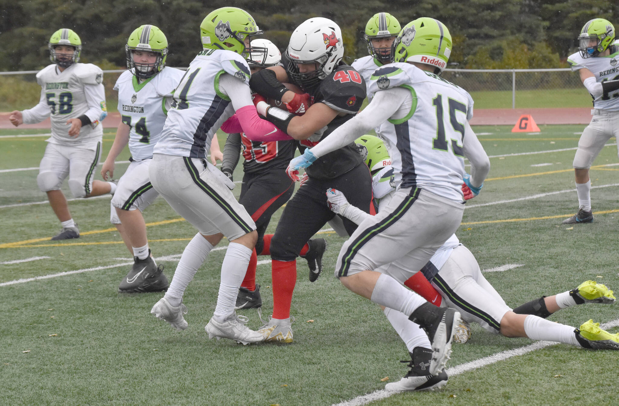 Kenai Central’s Bobby Hayes drags Redington tacklers for a gain Saturday, Sept. 16, 2023, at Ed Hollier Field at Kenai Central High School in Kenai, Alaska. (Photo by Jeff Helminiak/Peninsula Clarion)