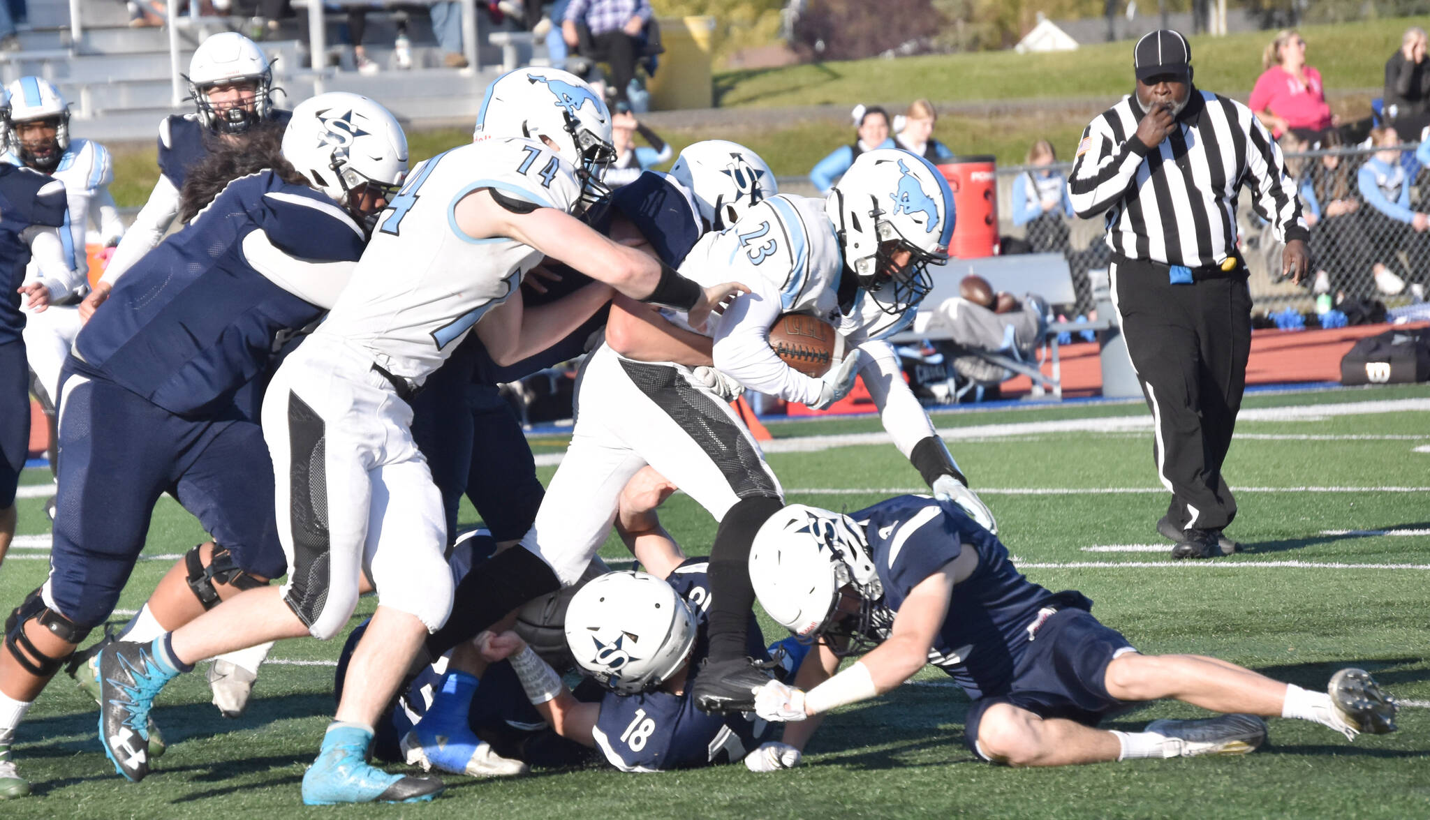 The Soldotna defense teams up to bring down Chugiak’s Tyson Billman on Friday, Sept. 22, 2023, at Justin Maile Field at Soldotna High School in Soldotna, Alaska. (Photo by Jeff Helminiak/Peninsula Clarion)