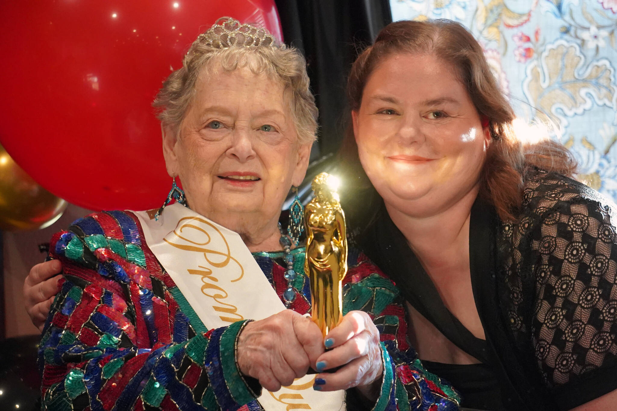 Senior Prom Queen Lorraine Ashcraft sits for a photo with Life Enrichment Director Carrie Nelson at the 2023 High Roller Senior Prom at Aspen Creek Senior Living in Kenai, Alaska, on Friday, Sept. 22, 2023. (Jake Dye/Peninsula Clarion)