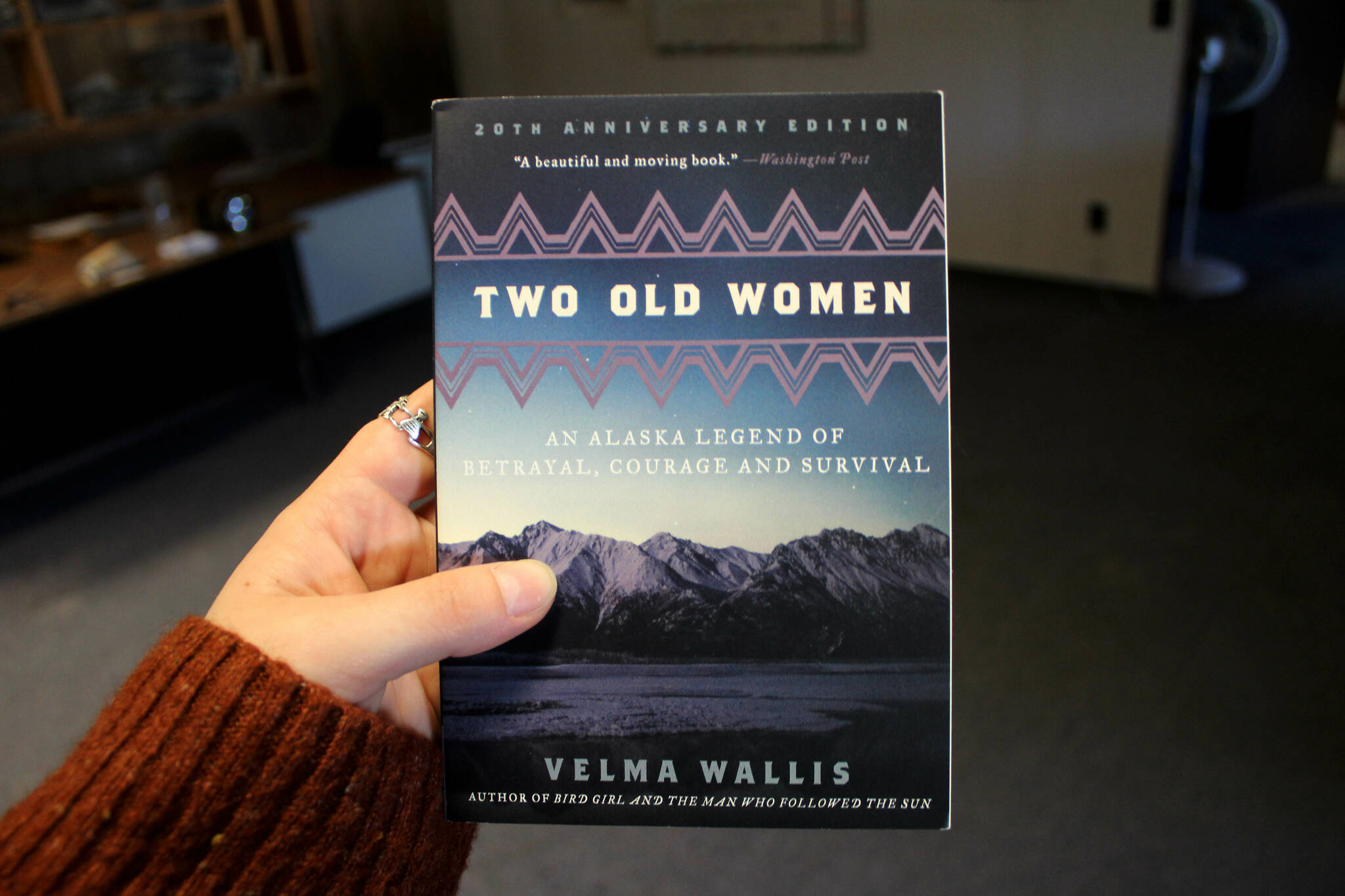 A copy of “Two Old Women” is held inside the Peninsula Clarion offices on Monday, Sept. 25, 2023, in Kenai, Alaska. (Ahlyn O’Hara/Peninsula Clarion)