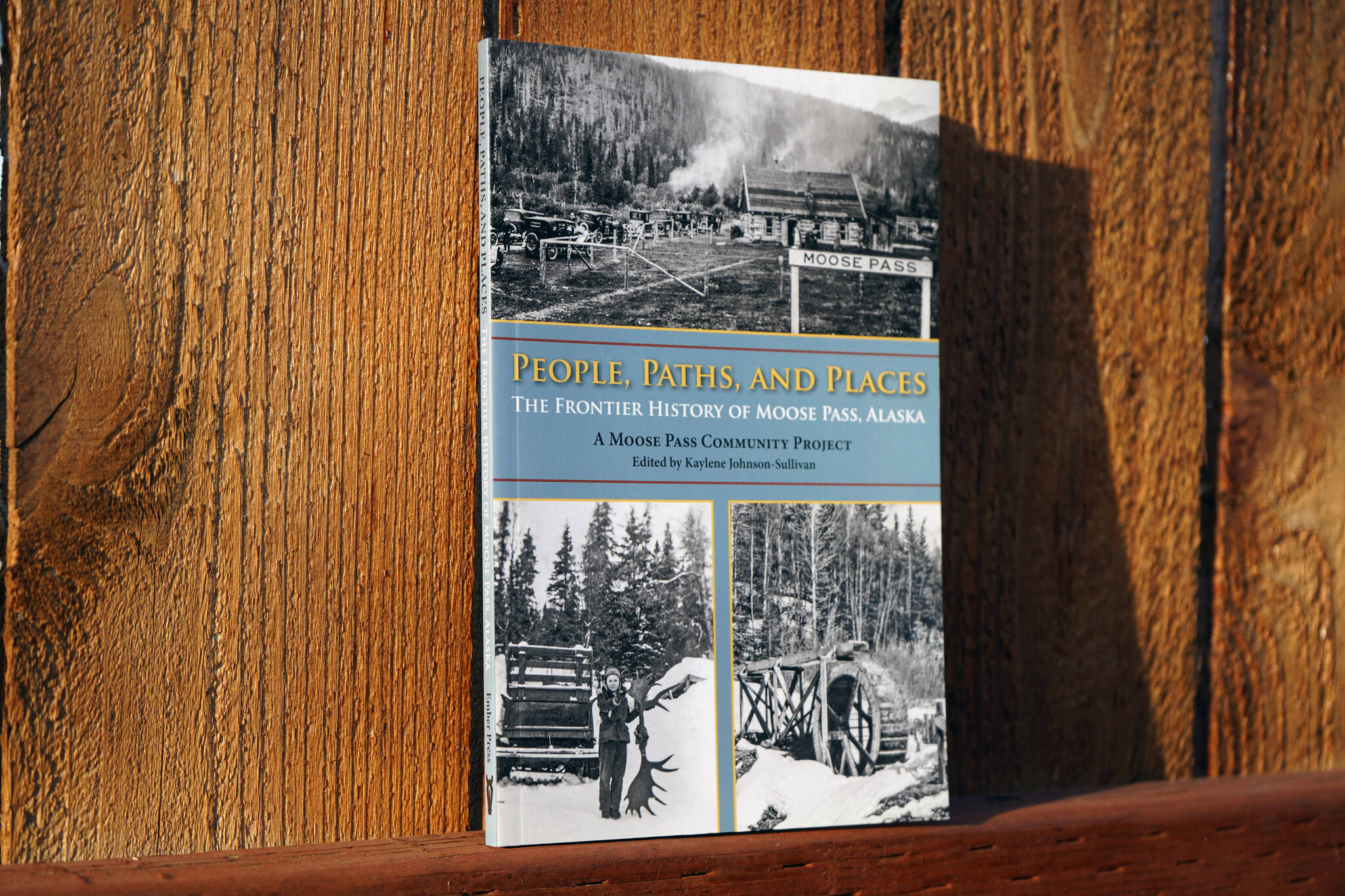 A copy of "People, Paths, and Places: The Frontier History of Moose Pass, Alaska" stands in sunlight in Soldotna, Alaska, on Friday, Sept. 29, 2023. (Jake Dye/Peninsula Clarion)