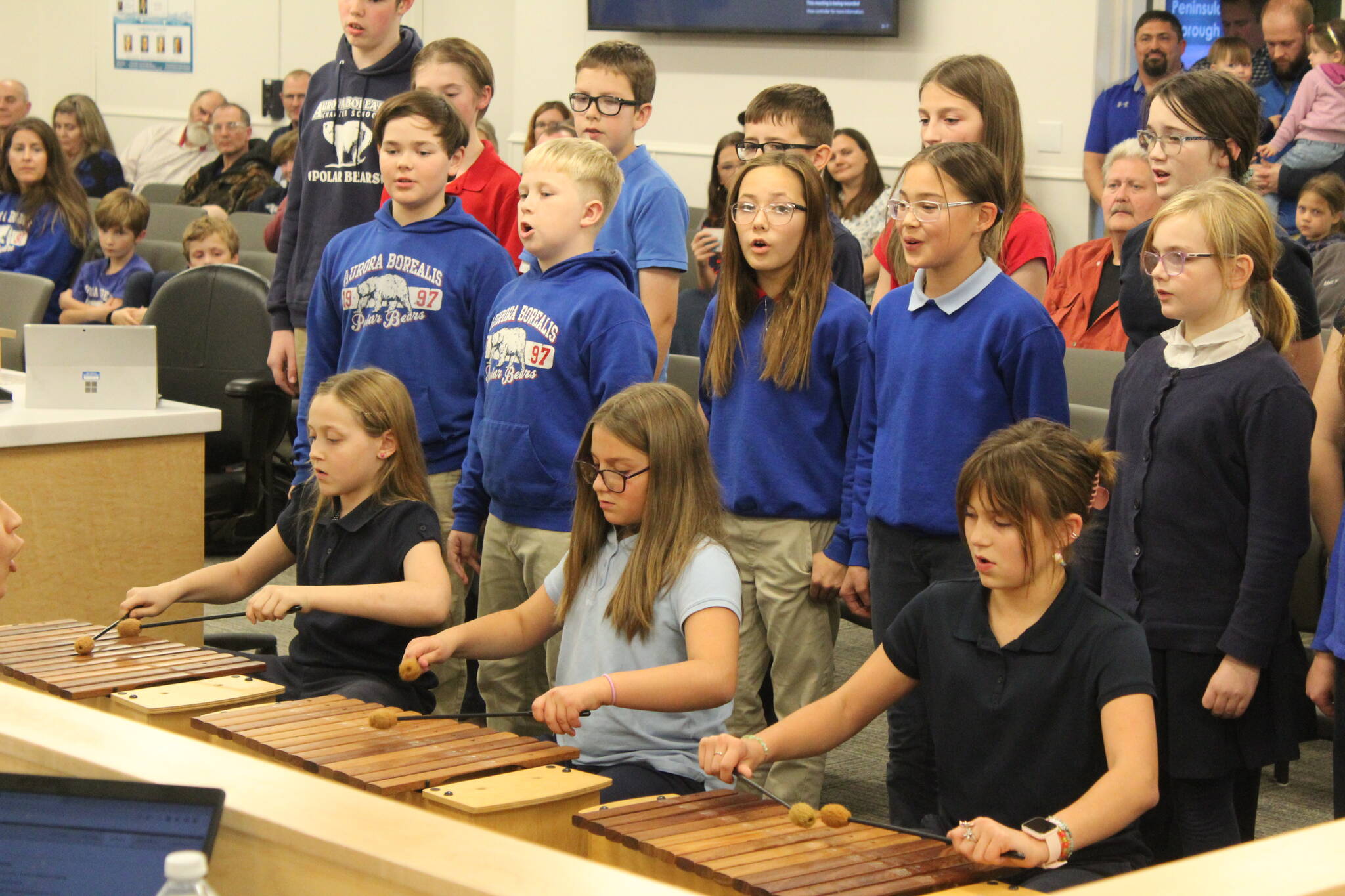 Aurora Borealis Charter School Art and Music Teacher Eleanor Van Sickle leads students in a performance of "Autumn Canon," a Hungarian song at a meeting of the Kenai Peninsula Borough School District Board of Education meeting on Monday, Oct. 2, 2023 in Soldotna, Alaska. (Ashlyn O'Hara/Peninsula Clarion)