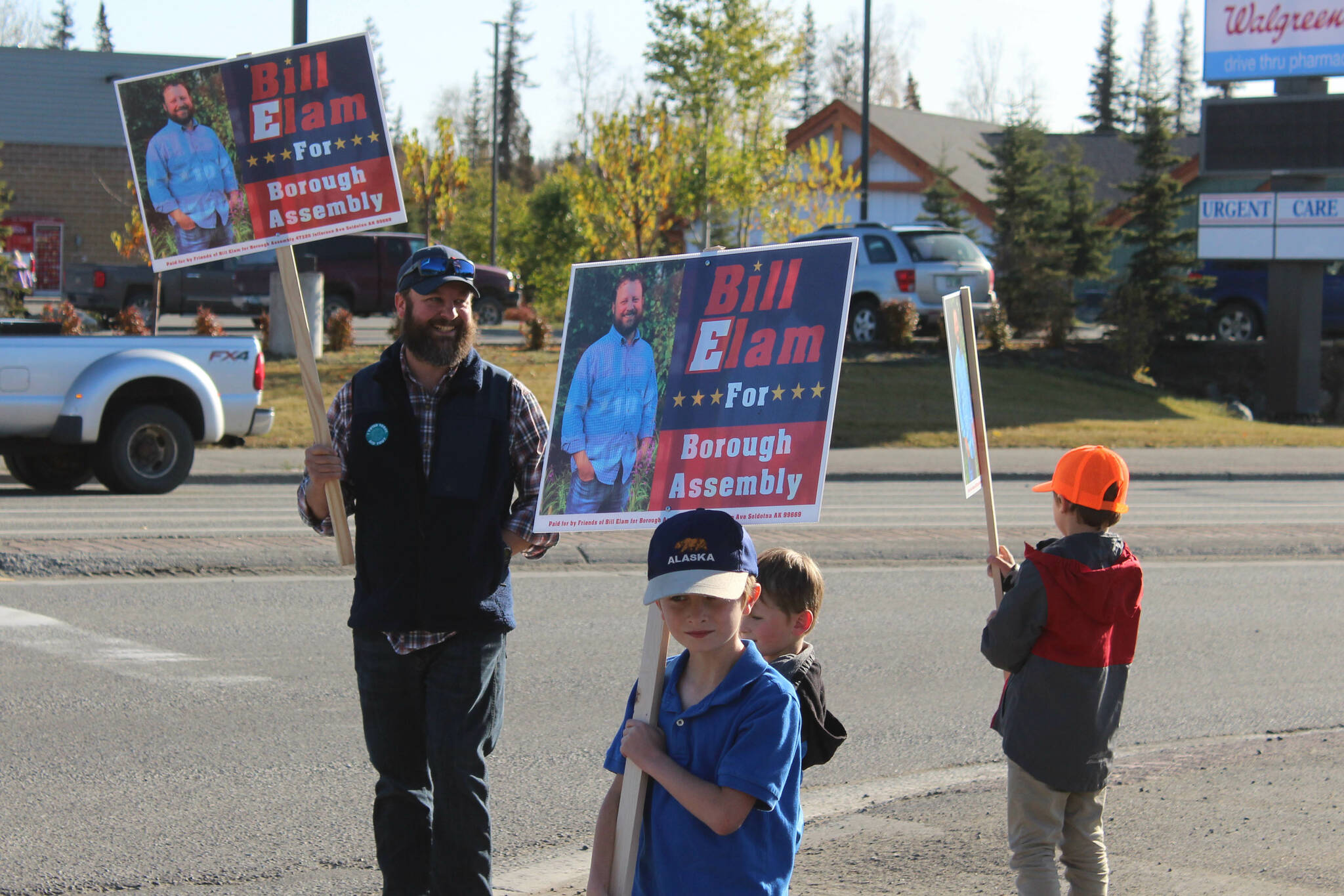 From left: Kenai Peninsula Borough Assembly candidate Bill Elam waves signs with his sons, William, Andrew and James on election day on Tuesday, Oct. 3, 2023, in Soldotna, Alaska. (Ashlyn O’Hara/Peninsula Clarion)