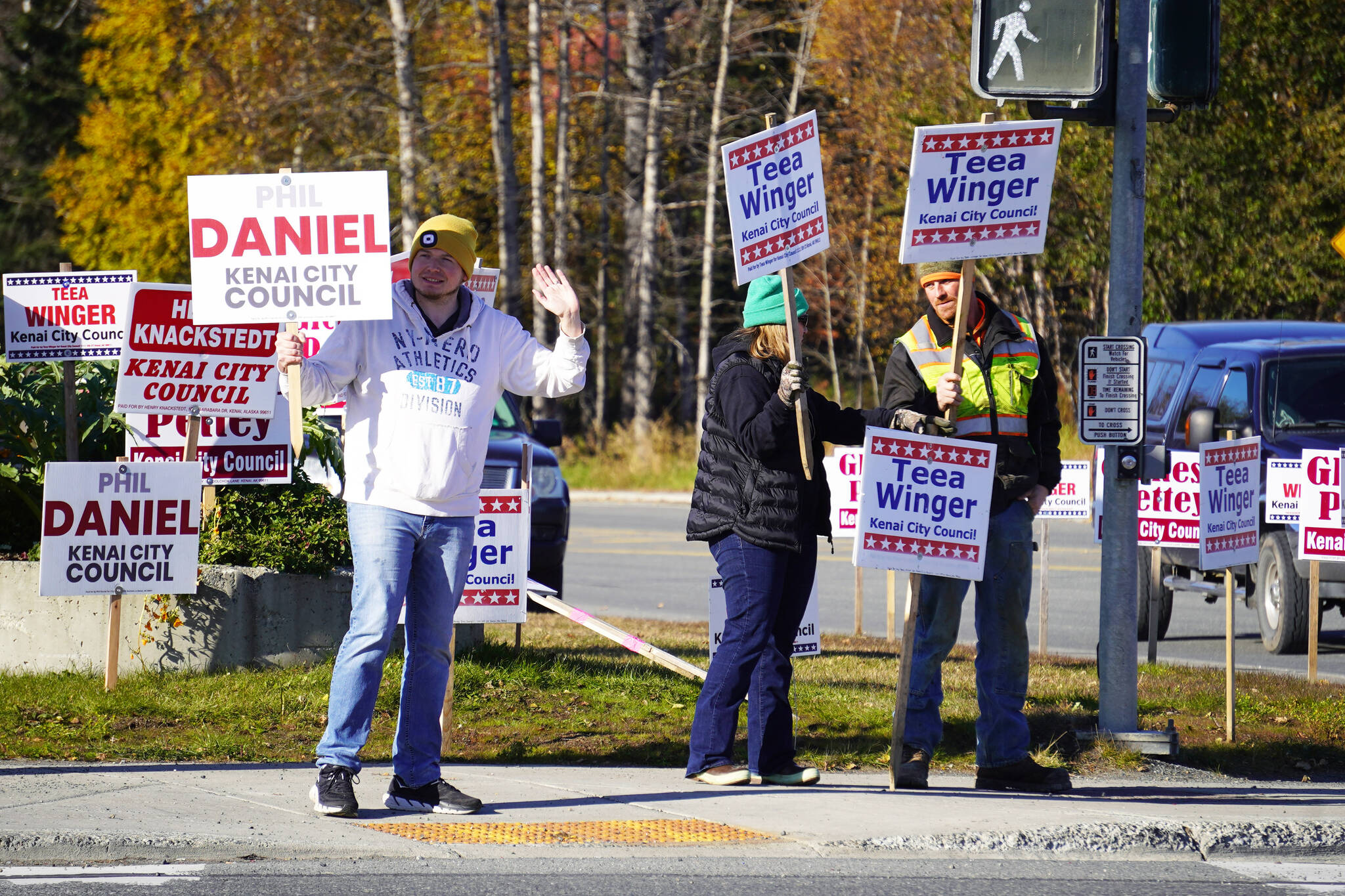 Phil Daniel, left, joins supporters of Teea Winger in waving signs on the corner of Bridge Access Road and the Kenai Spur Highway in Kenai, Alaska, for election day on Tuesday, Oct. 3, 2023. (Jake Dye/Peninsula Clarion)