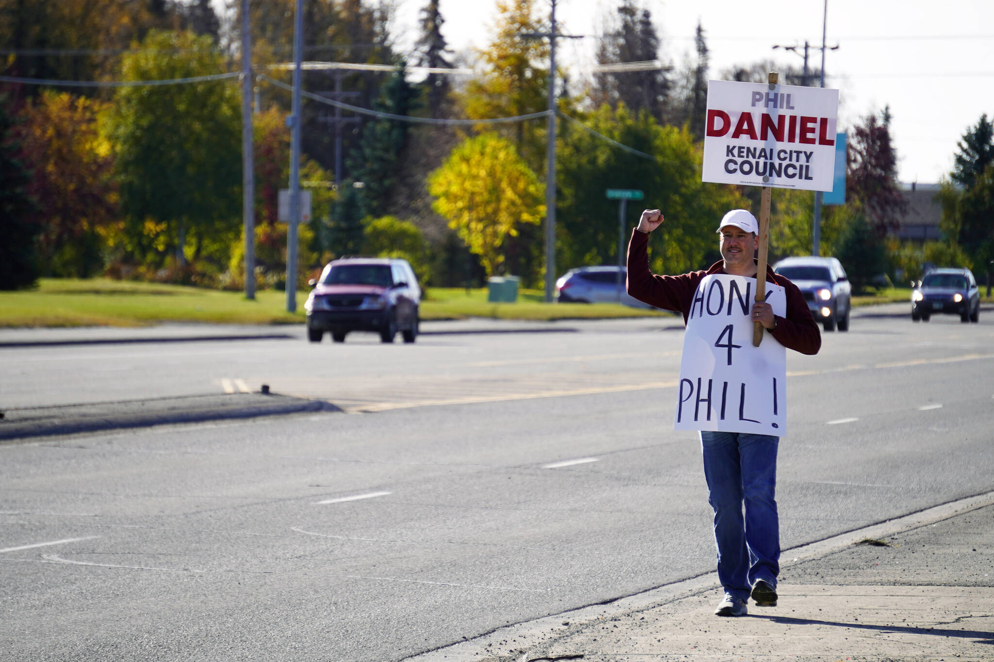 A supporter of Phil Daniel calls on drivers to honk their horns along the Kenai Spur Highway in Kenai, Alaska, during election day on Tuesday, Oct. 3, 2023. (Jake Dye/Peninsula Clarion)
