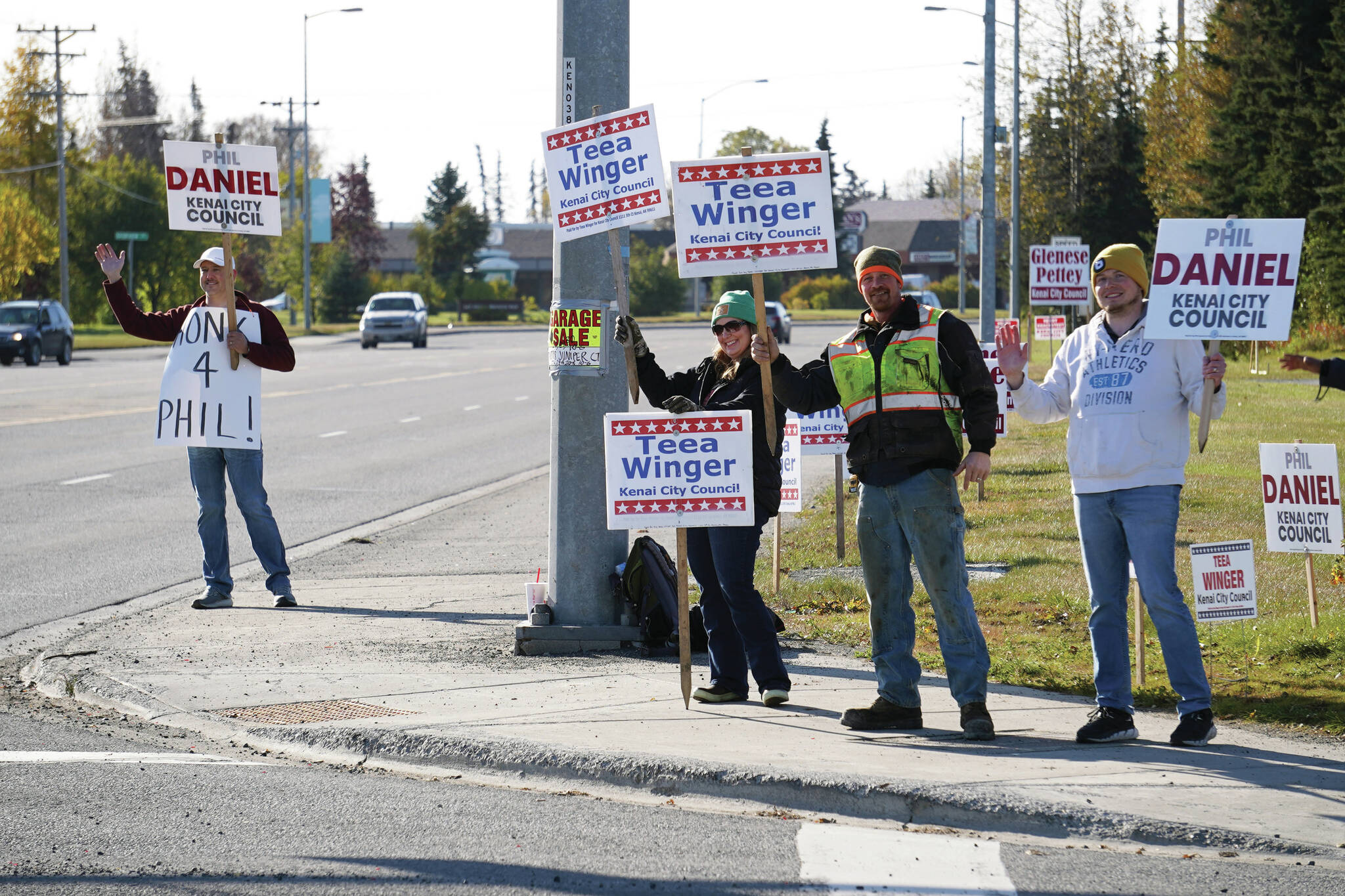 Phil Daniel, left, joins supporters of both himself and Teea Winger in waving signs on the corner of Bridge Access Road and the Kenai Spur Highway in Kenai, Alaska, for election day on Tuesday, Oct. 3, 2023. (Jake Dye/Peninsula Clarion)