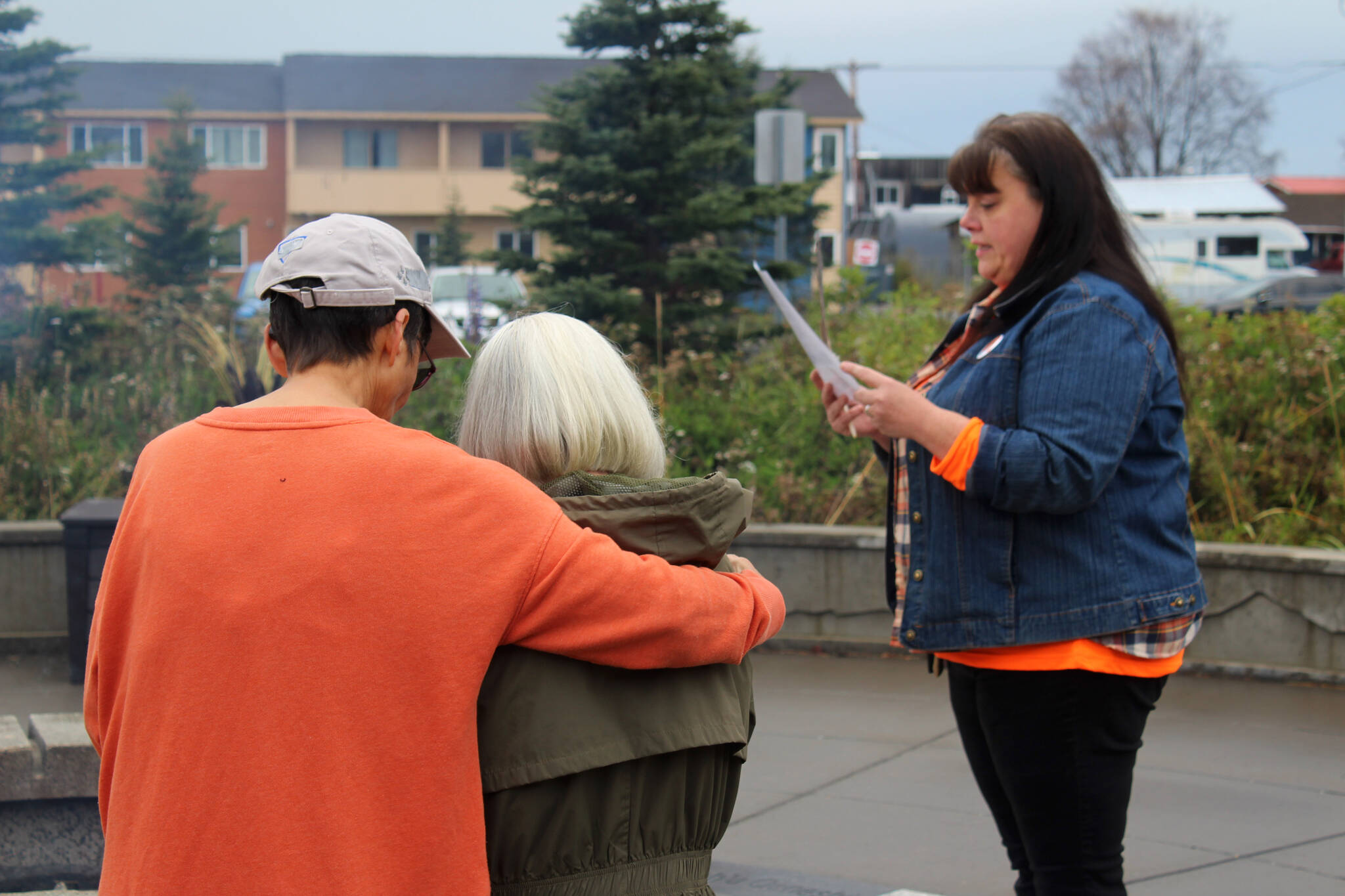 Kenaitze Tribal Elder Sharon Isaak comforts boarding school survivor Mary Hunt while Traditional Healer Karen Trulove reads a prayer at Ggugguyni T'uh, "Raven Place," outside the Dena'ina Wellness Center on Friday, Oct. 6, 2023 in Kenai, Alaska. Orange Shirt Day honors indigenous elders who survived and children lost from boarding schools established to detribalize indigenous people. (Ashlyn O'Hara/Peninsula Clarion)