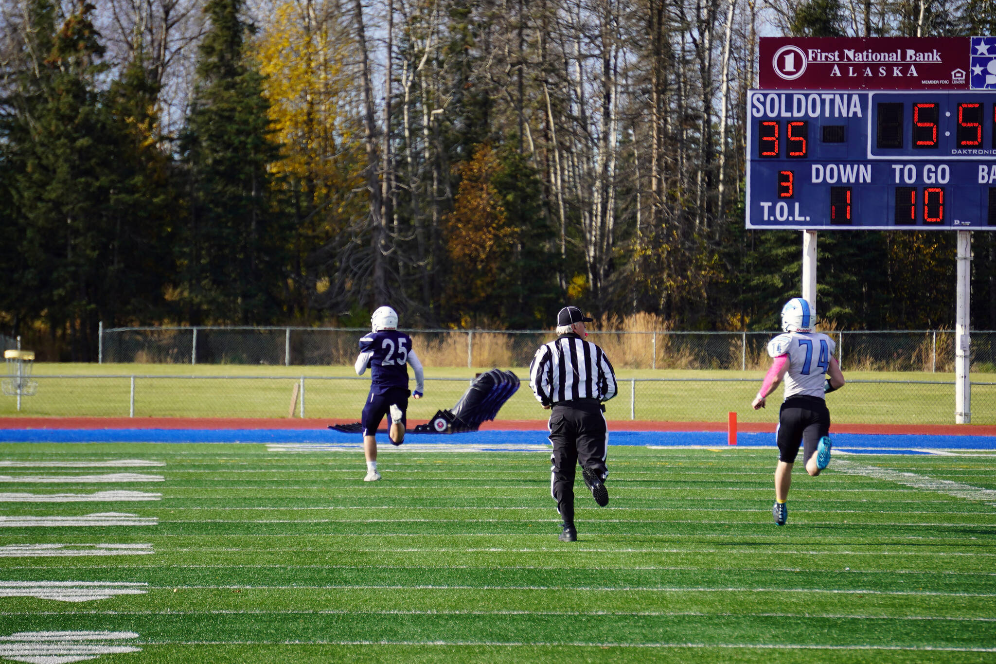 Soldotna’s Gehret Medcoff completes a 95 yard run for a touchdown, pursued by Chugiak’s Ethan Maddox, during a Division II playoff game at Justin Maile Field in Soldotna, Alaska, on Saturday, Oct. 7, 2023. (Jake Dye/Peninsula Clarion)