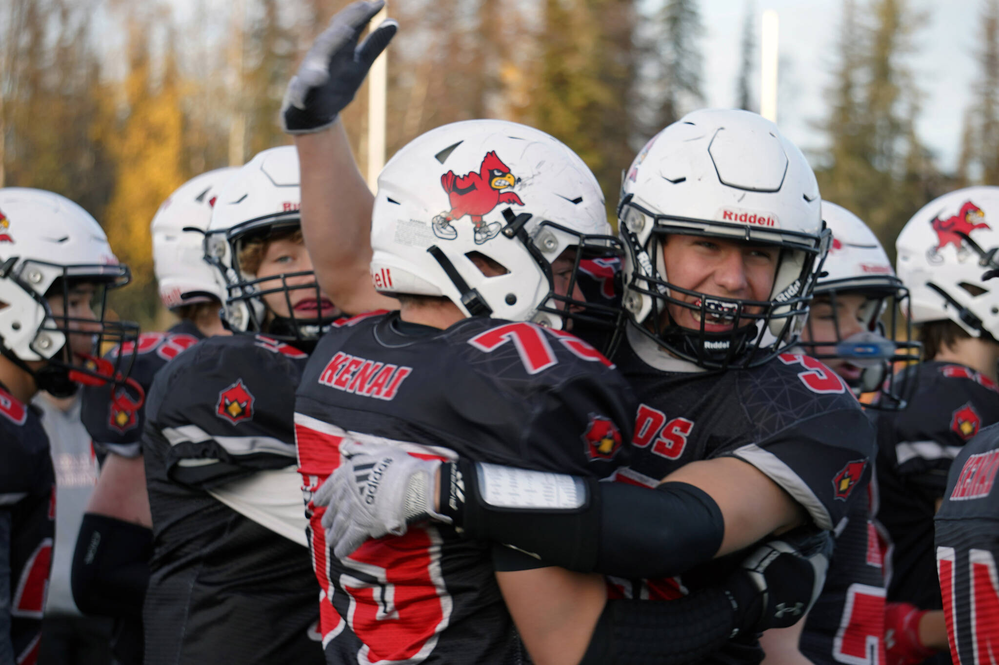 Kenai’s Spencer Maw is embraced by Logan Myers after recovering an onside kick to keep the Kardinals in the game with less than a minute on the clock during a Division III playoff game at Justin Maile Field in Soldotna, Alaska, on Saturday, Oct. 7, 2023. (Jake Dye/Peninsula Clarion)