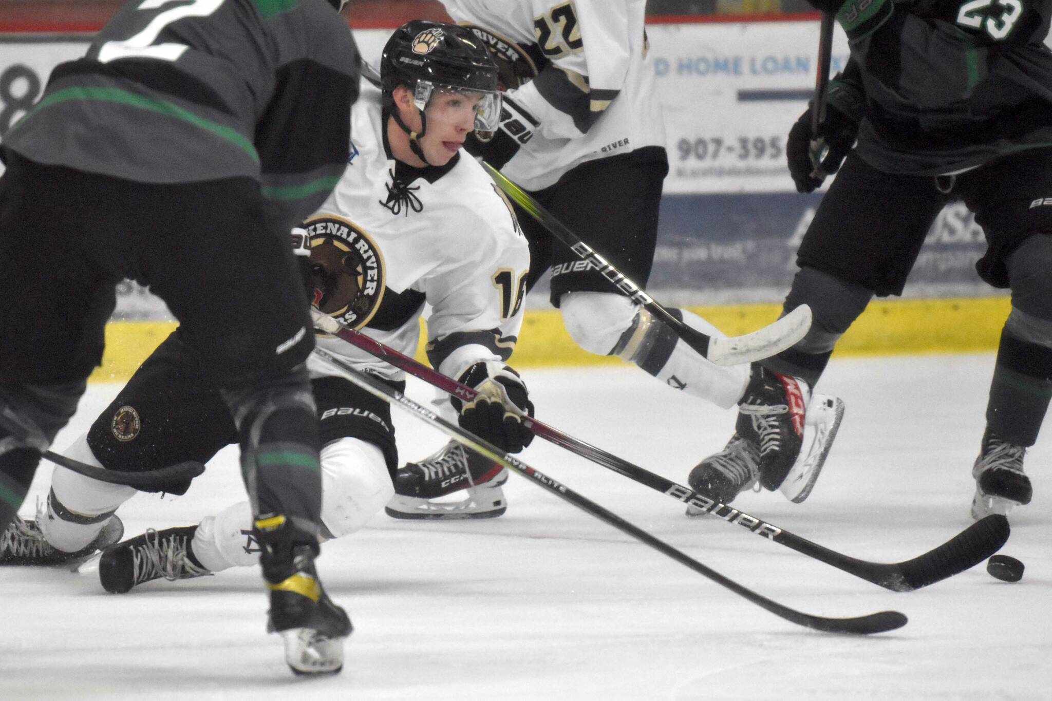 Carter McCormick of the Kenai River Brown Bears makes a play as he falls to the ice Friday, Oct. 13, 2023, at the Soldotna Regional Sports Complex in Soldotna, Alaska. (Photo by Jeff Helminiak/Peninsula Clarion)