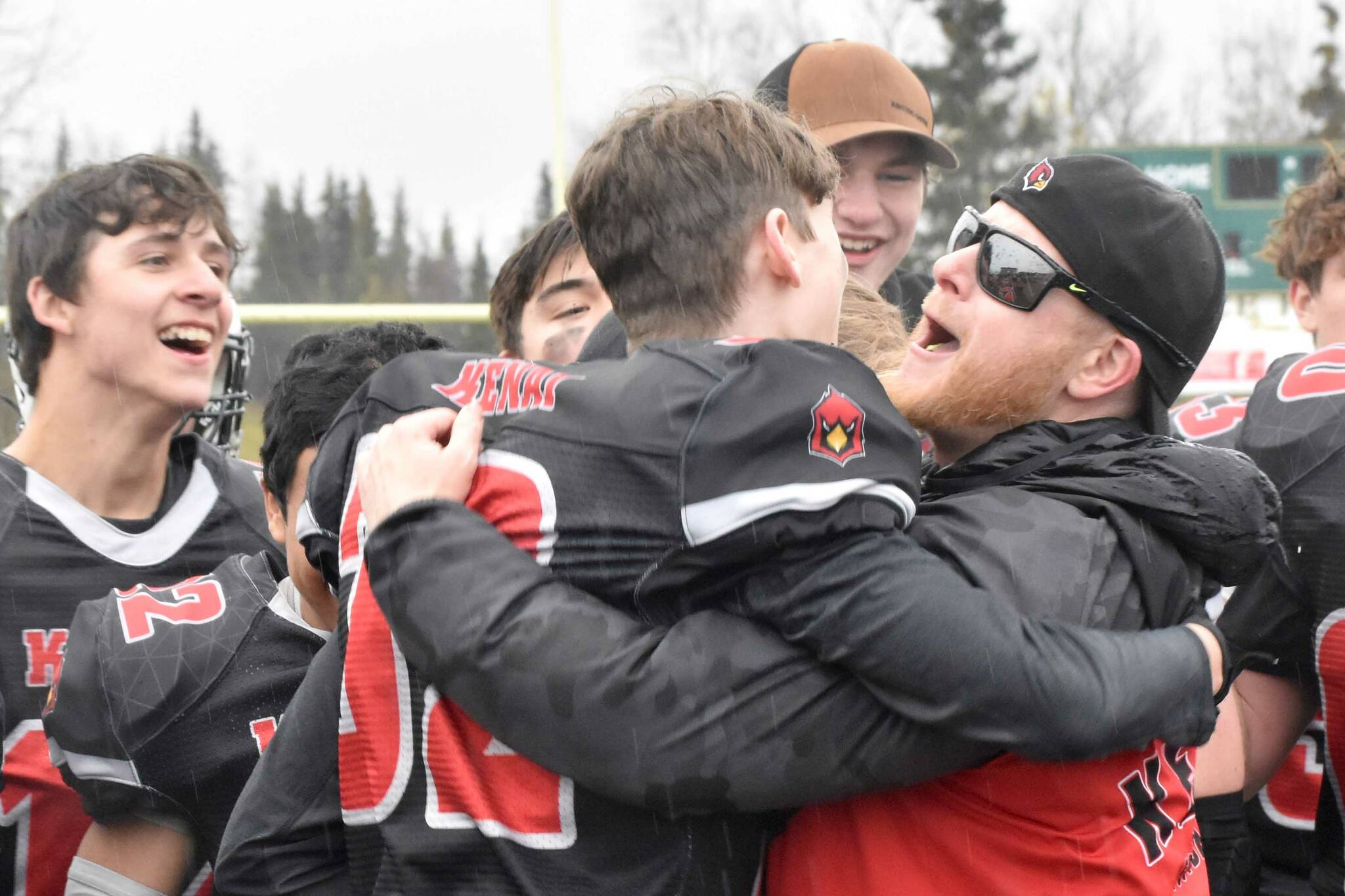 Kenai Central head coach Jake Brand celebrates victory with the team Saturday, Oct. 14, 2023, in the Division III state championship game at Service High School in Anchorage, Alaska. (Photo by Jeff Helminiak/Peninsula Clarion)