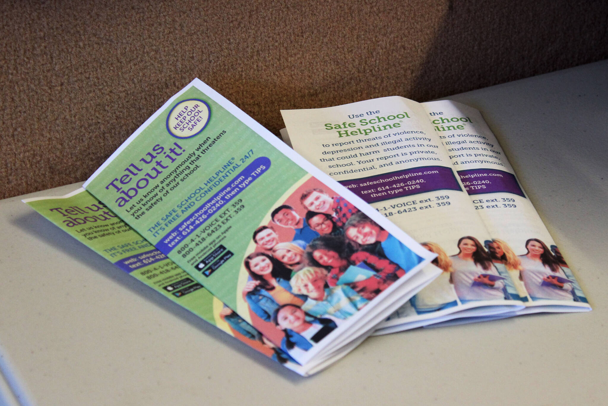 Brochures advertise information about the Safe School Helpline near the entrance to Hope School on Wednesday, Oct. 19, 2023, in Hope, Alaska. (Ashlyn O’Hara/Peninsula Clarion)