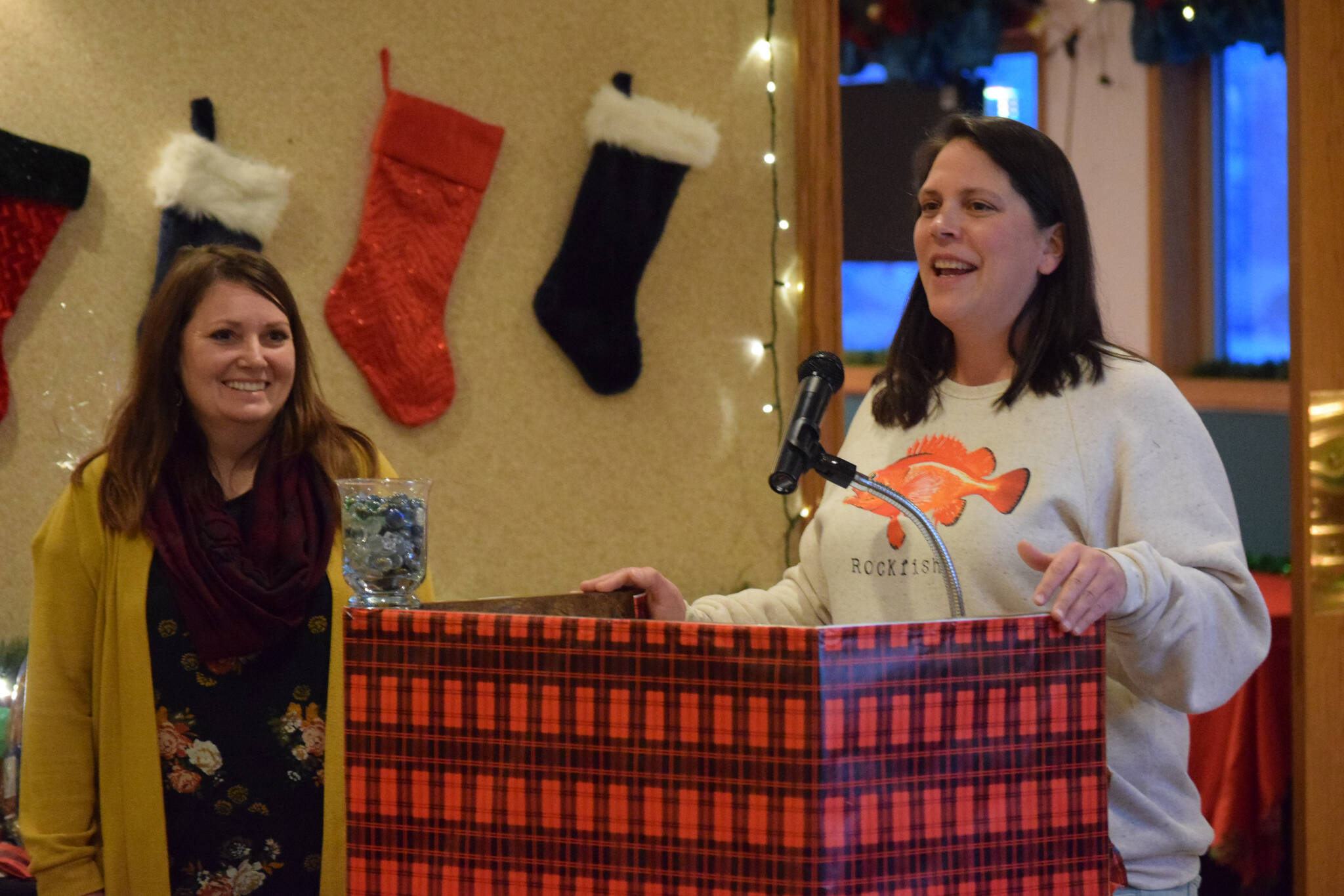 Jacquelynn Tomrdle, left, and Nicole Murphy, right, present on behalf of the Kenai Peninsula Borough School District Students in Transition program at the Kenai Peninsula Association of Realtors award ceremony at Kenai Catering on Thursday, Dec. 9, 2021. (Camille Botello/Peninsula Clarion)