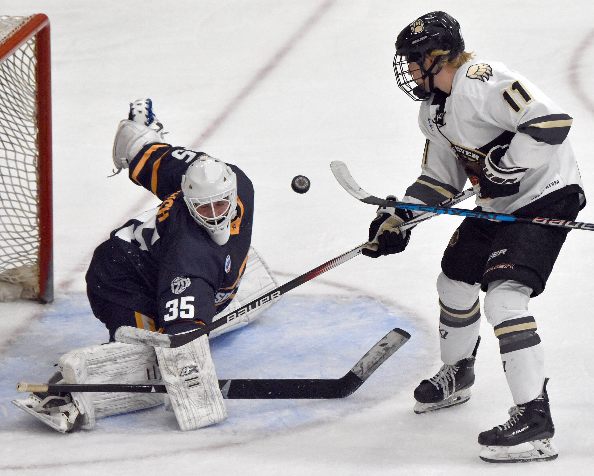 Springfield (Illinois) Jr. Blues goalie Nick Bunch makes a save on Kenai River Brown Bears forward Cade Baker on Friday, Oct. 27, 2023, at the Soldotna Regional Sports Complex in Soldotna, Alaska. (Photo by Jeff Helminiak/Peninsula Clarion)