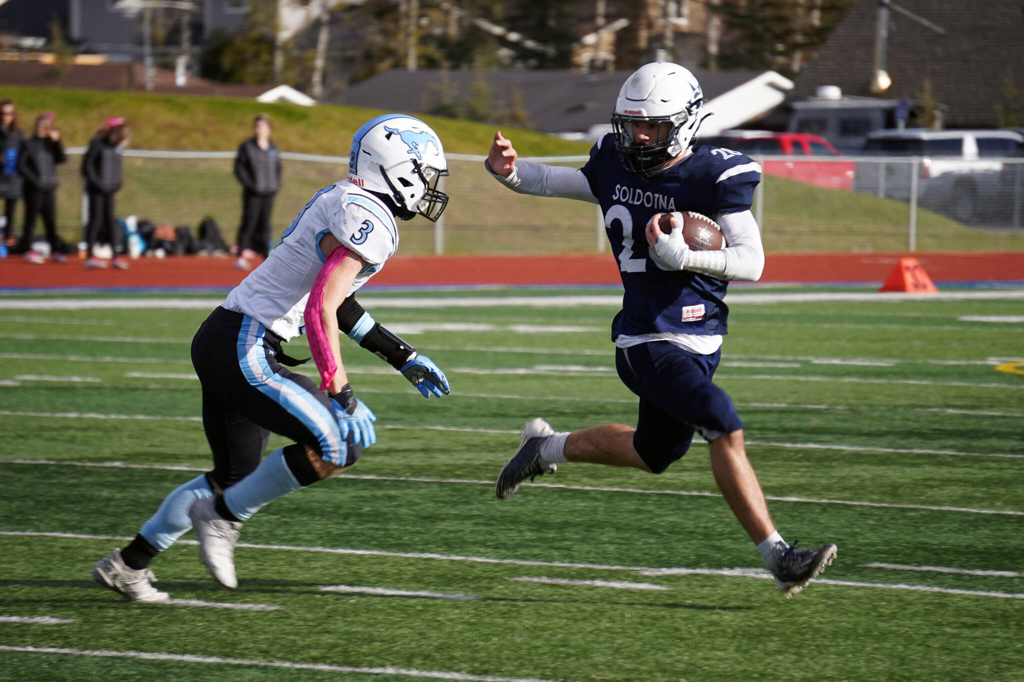Soldotna's Wyatt Faircloth runs with the ball while fending off Chugiak's Luke Poland during a Division II playoff game at Justin Maile Field in Soldotna, Alaska, on Saturday, Oct. 7, 2023. (Jake Dye/Peninsula Clarion)
