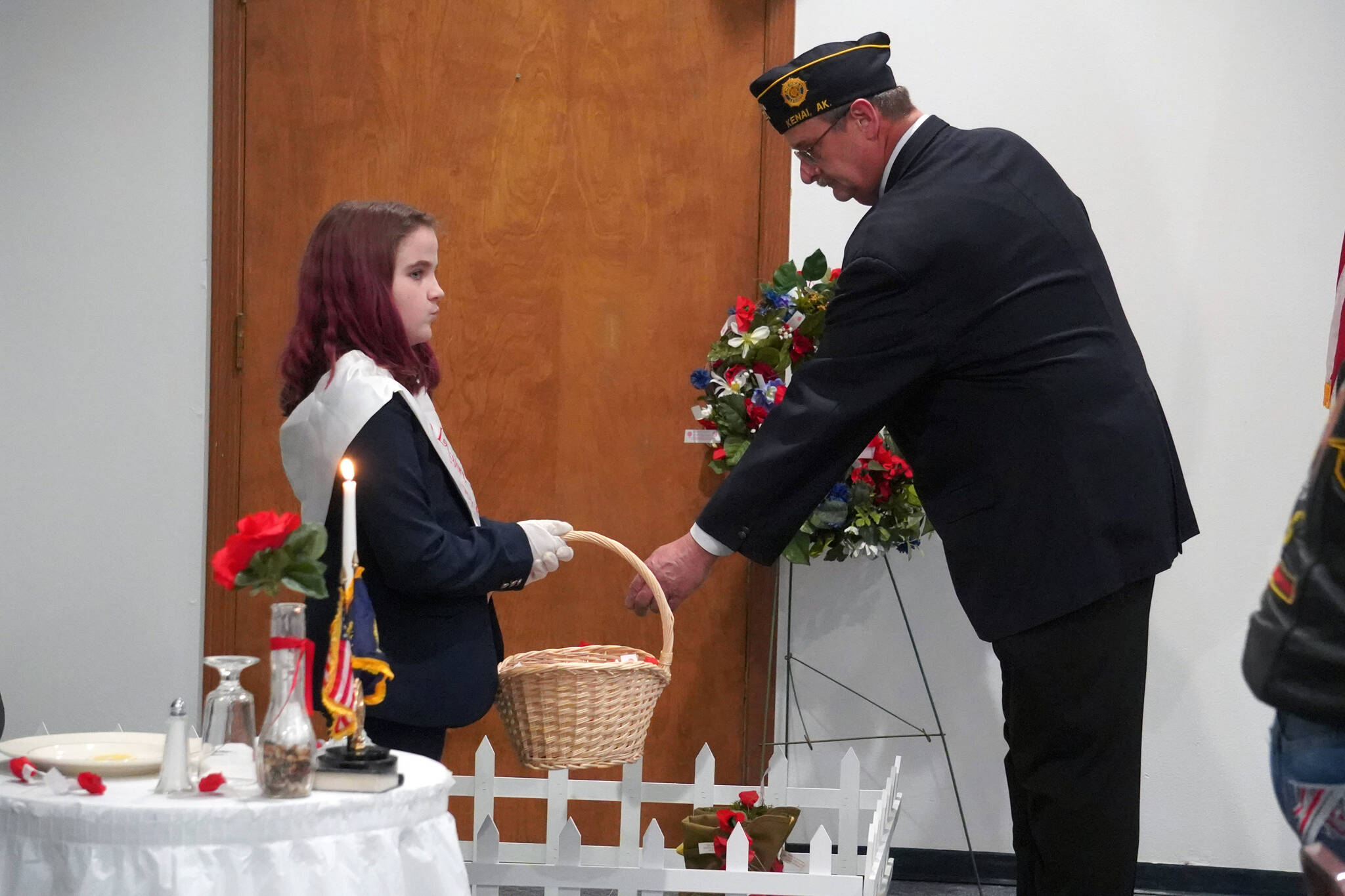 Post 20 Past Cmdr. David Segura places poppies on a symbolic grave during a Veterans Day celebration at the American Legion Post 20 in Kenai, Alaska, on Saturday, Nov. 11, 2023. (Jake Dye/Peninsula Clarion)