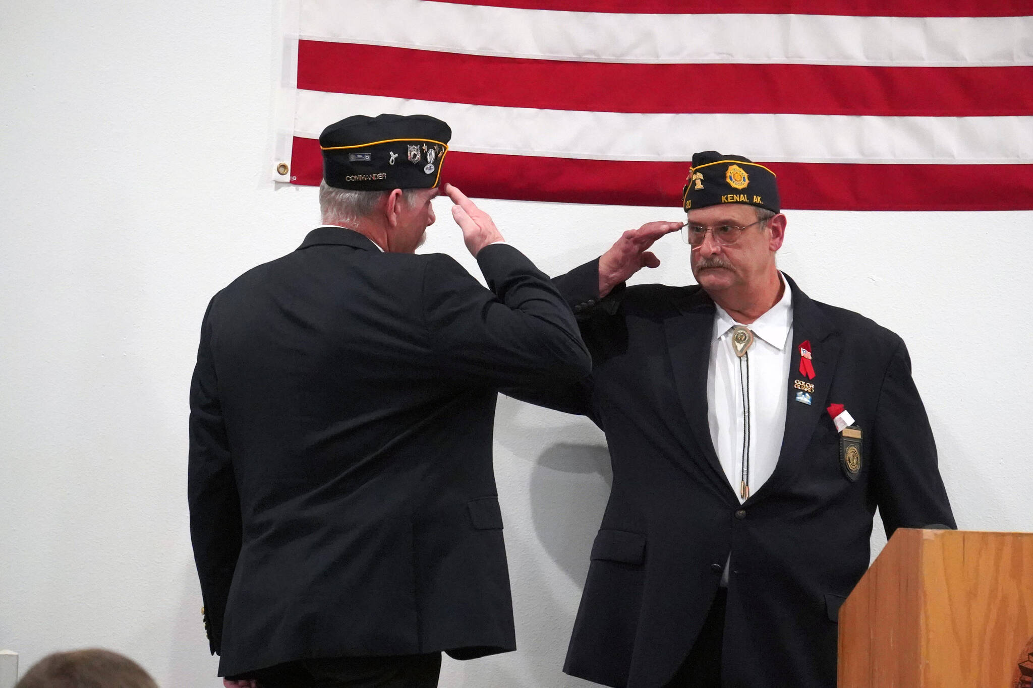 American Legion Post 20 Cmdr. Ron Homan shares a salute with Past Cmdr. Dave Segura before speaking during a Veterans Day celebration at the American Legion Post 20 in Kenai, Alaska, on Saturday, Nov. 11, 2023. (Jake Dye/Peninsula Clarion)