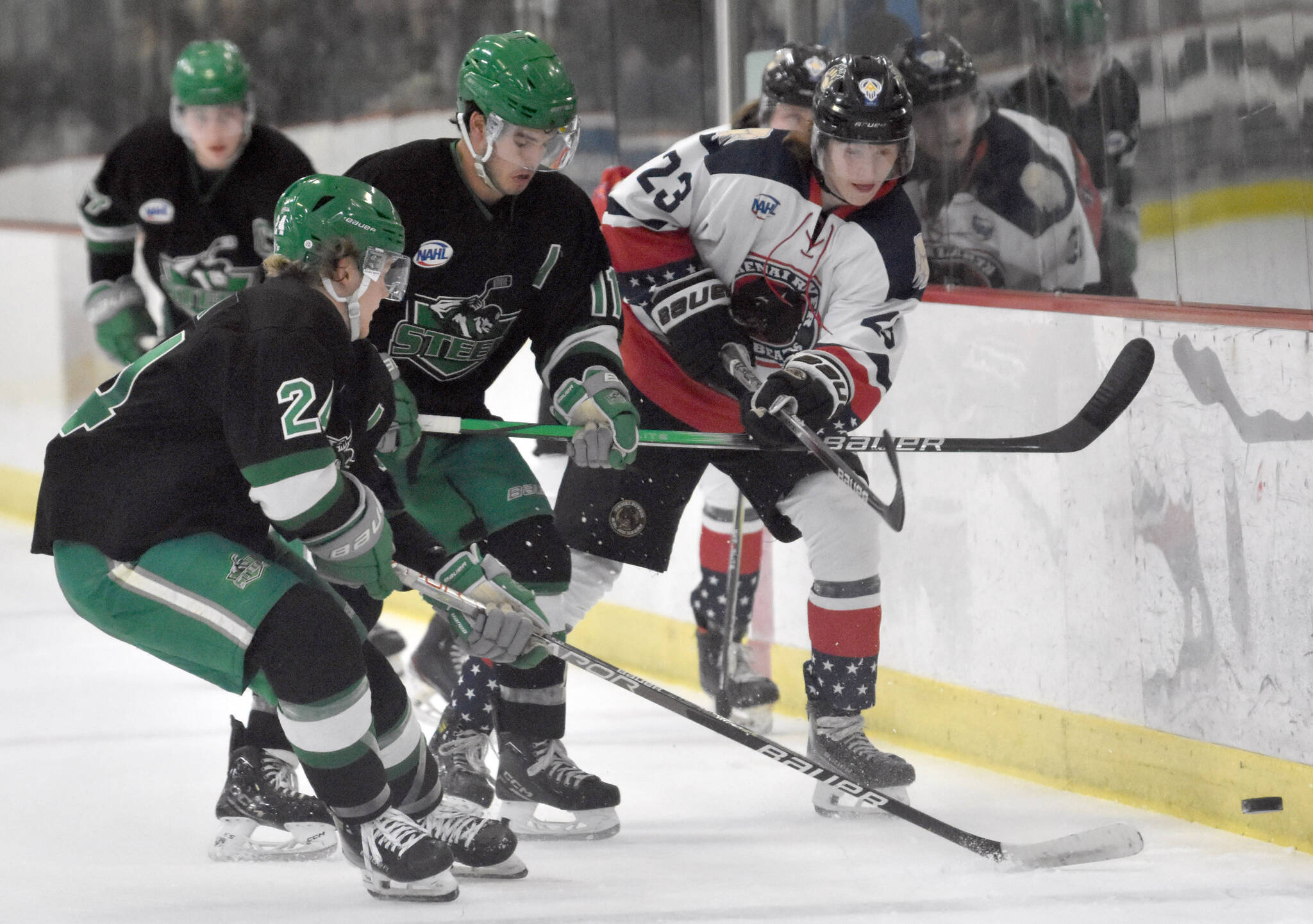 Jackson Ebbott of the Kenai River Brown Bears advances the puck past Nick Hatton and Joe Kelly of the Chippewa (Wisconsin) Steel on Sunday, Nov. 12, 2023, at the Soldotna Regional Sports Complex in Soldotna, Alaska. (Photo by Jeff Helminiak/Peninsula Clarion)