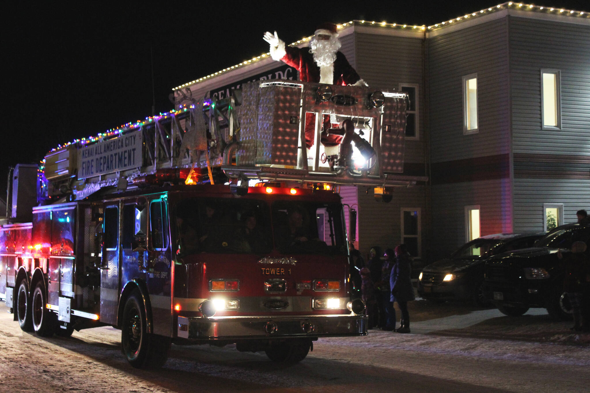Santa Claus waves from the top of a Kenai Fire Department fire engine during the “Christmas Comes to Kenai” parade on Friday, Nov. 26, 2021 in Kenai, Alaska. (Ashlyn O’Hara/Peninsula Clarion)