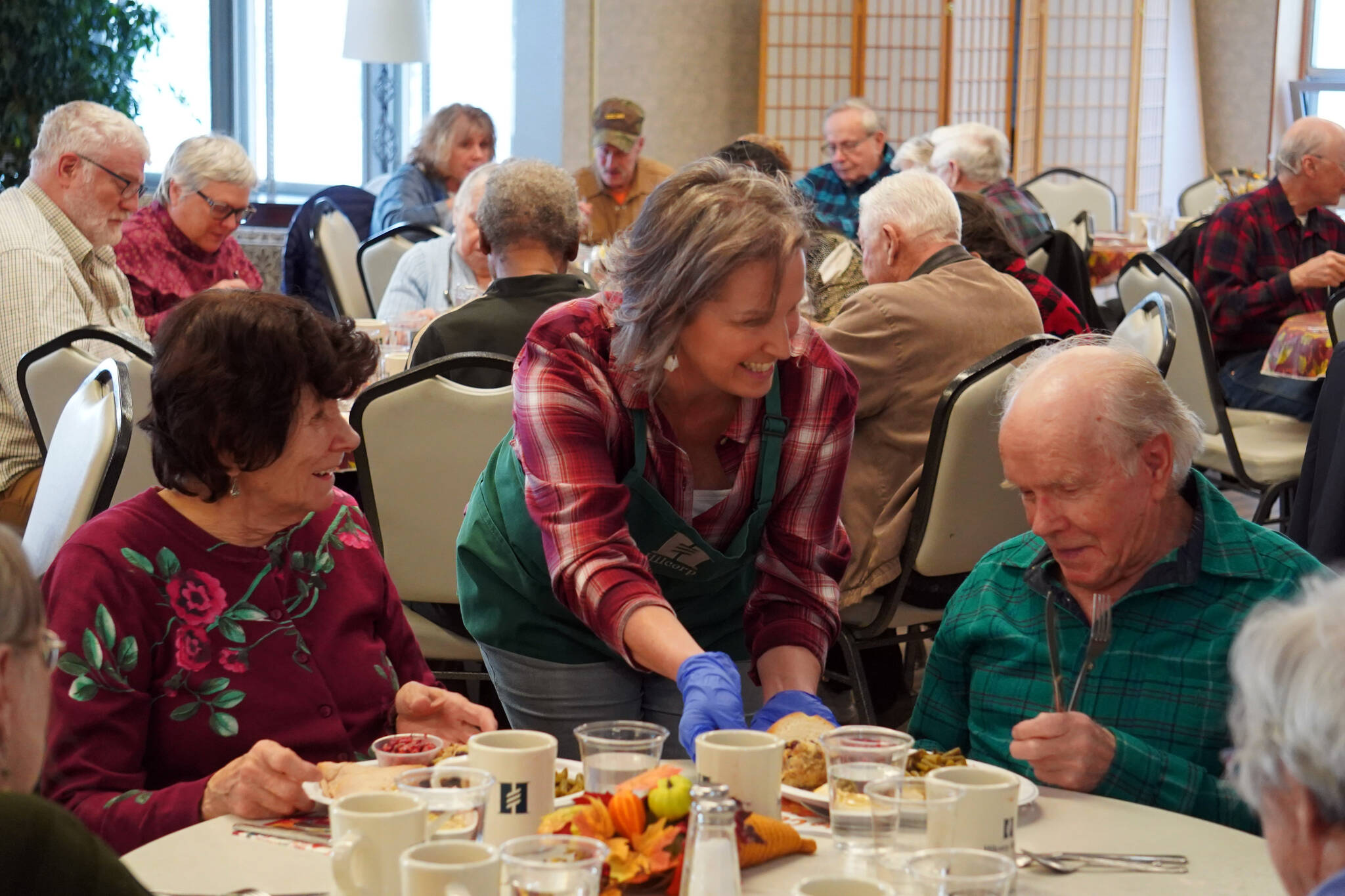 Representatives of Hilcorp distribute Thanksgiving dinners to seniors at the Kenai Senior Center in Kenai, Alaska, on Friday, Nov. 17, 2023. (Jake Dye/Peninsula Clarion)