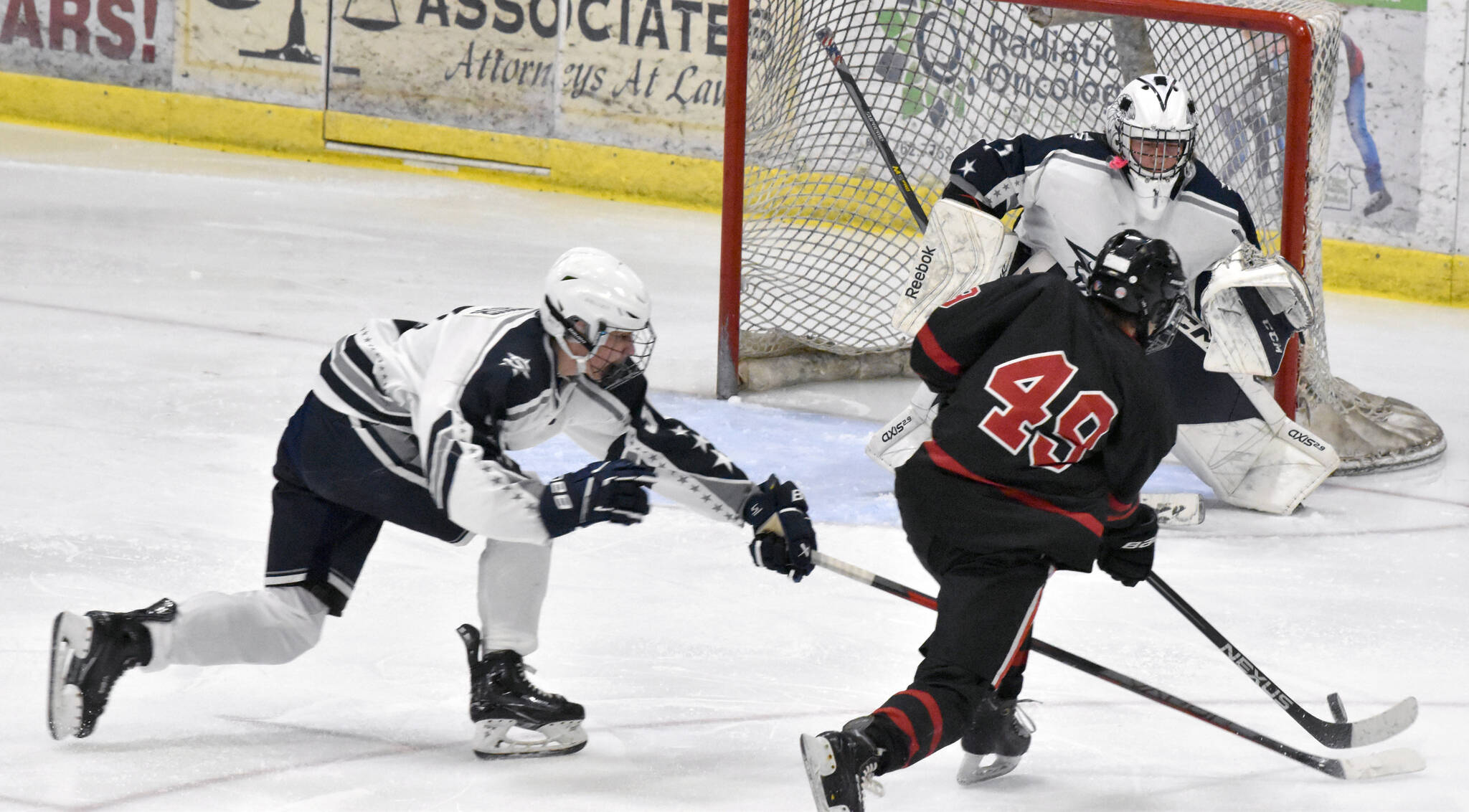 Soldotna defenseman Andrew Arthur and goalie Tanner Clyde work to stop a shot from Juneau-Douglas: Yadaa.at Kale’s Xavier Melancon on Friday, Nov. 17, 2023, at the Soldotna Regional Sports Complex in Soldotna, Alaska. (Photo by Jeff Helminiak/Peninsula Clarion)