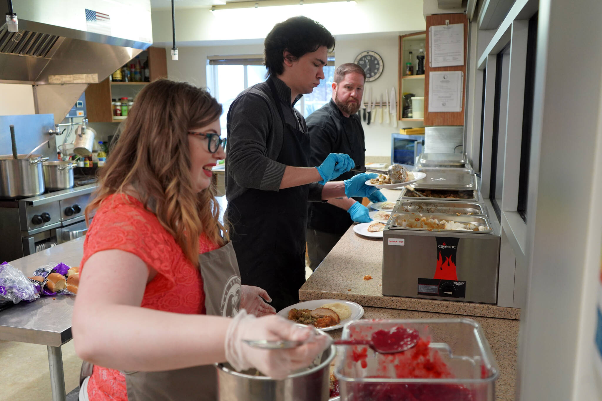 Jesse Lamm, Coltin Yancey and Chef Stephen Lamm plate and serve the Thanksgiving meal at the Kenai Peninsula Food Bank in Soldotna, Alaska, on Wednesday, Nov. 22, 2023. (Jake Dye/Peninsula Clarion)