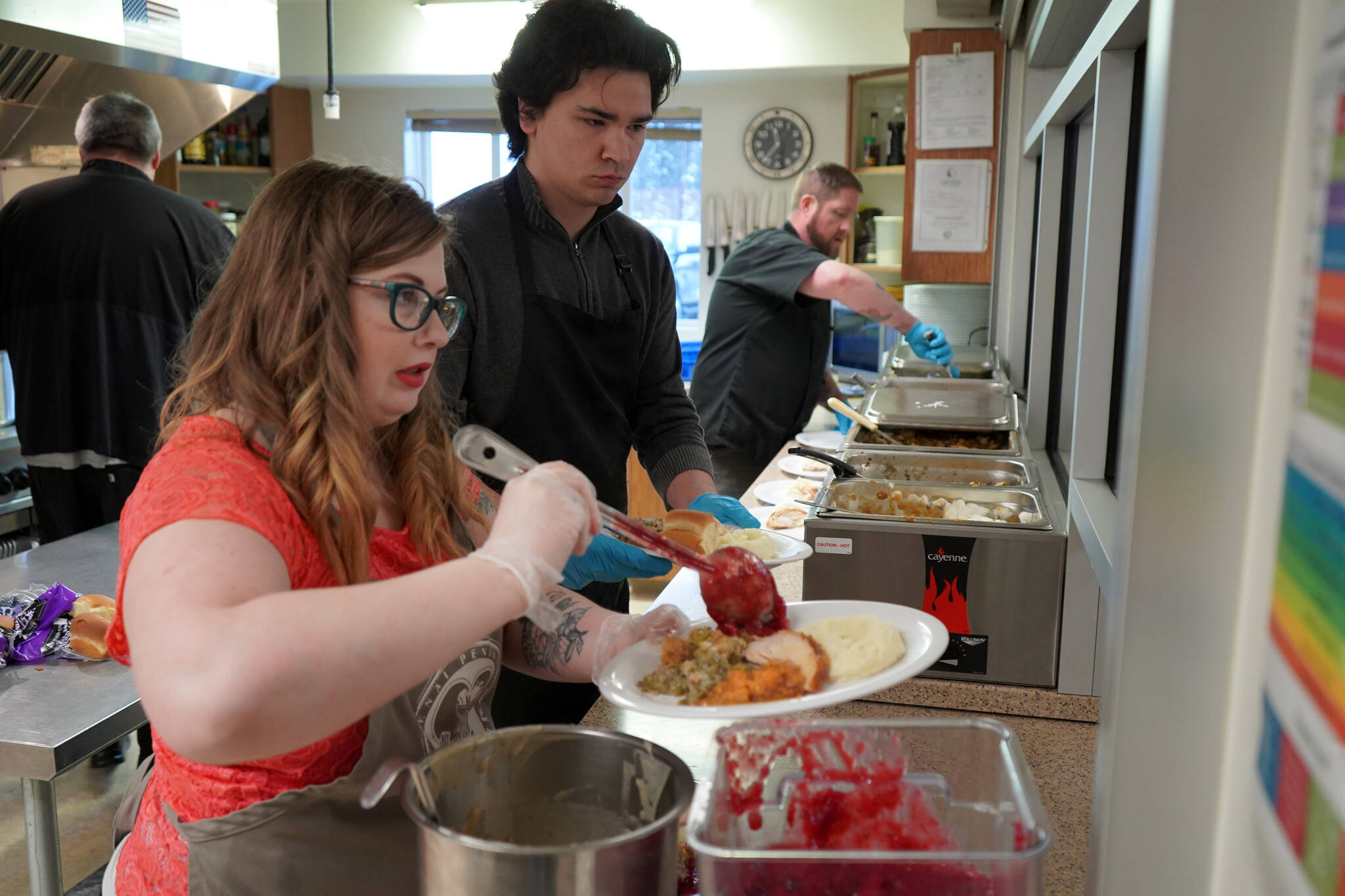 Jesse Lamm, Coltin Yancey and Chef Stephen Lamm plate and serve the Thanksgiving meal at the Kenai Peninsula Food Bank in Soldotna, Alaska, on Wednesday, Nov. 22, 2023. (Jake Dye/Peninsula Clarion)