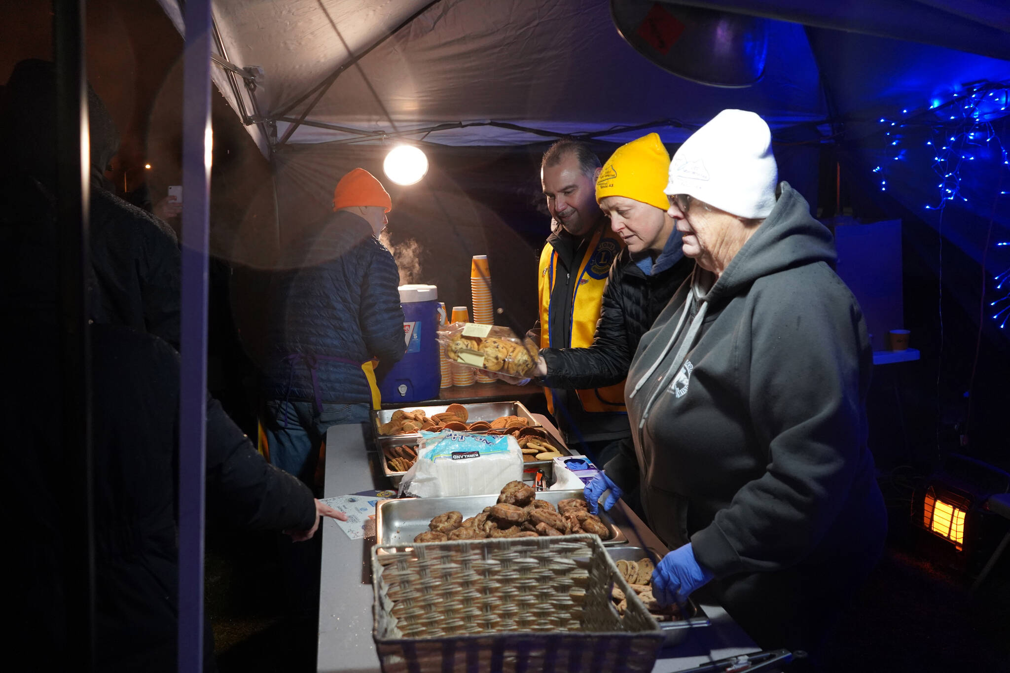 Lions Club members pass out hot chocolate and cookies during Christmas Comes to Kenai festivities at the Kenai Chamber of Commerce and Visitor Center in Kenai, Alaska, on Friday, Nov. 24, 2023. (Jake Dye/Peninsula Clarion)