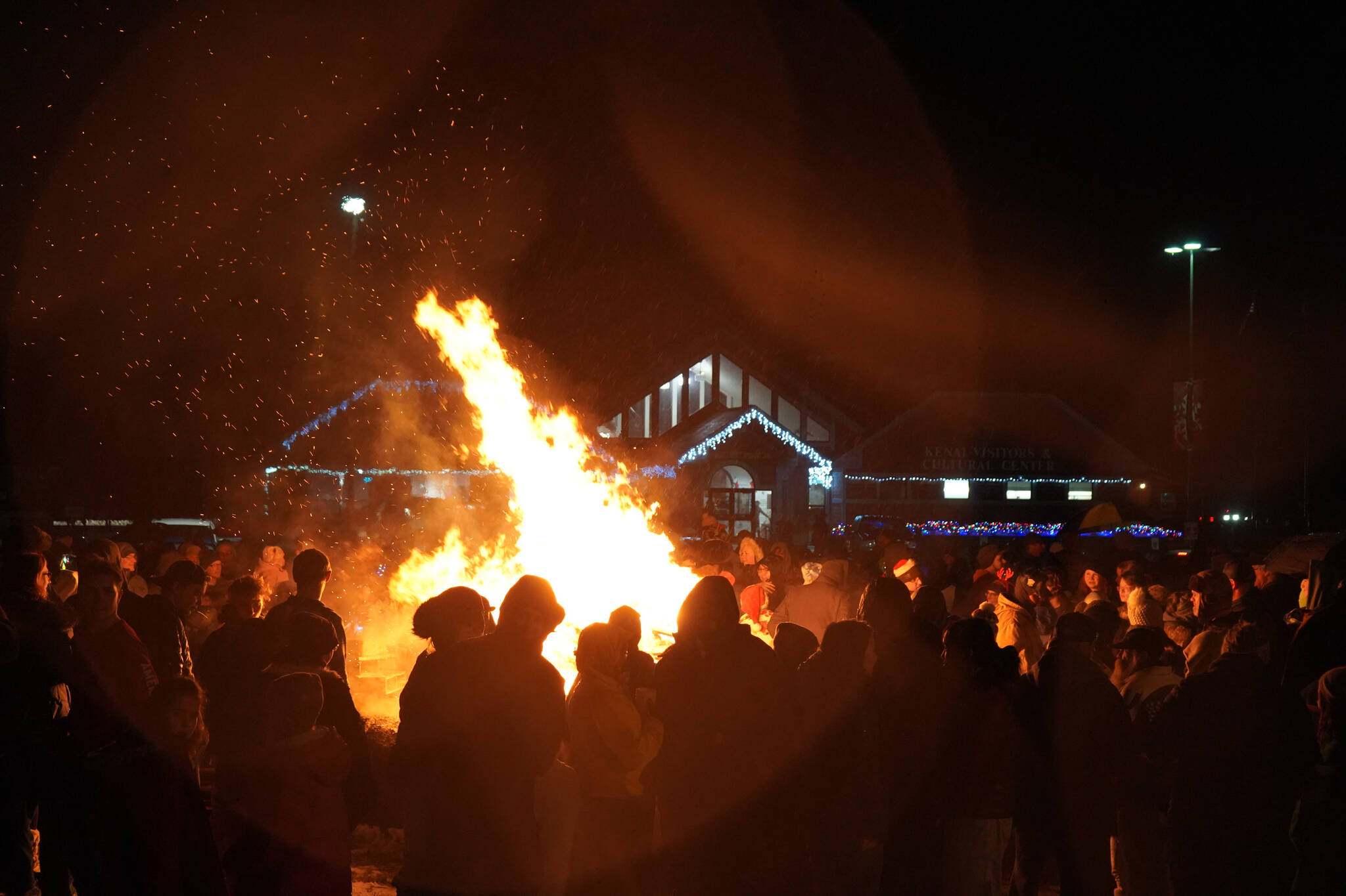 Hundreds pack around the bonfire during Christmas Comes to Kenai festivities at the Kenai Chamber of Commerce and Visitor Center in Kenai, Alaska, on Friday, Nov. 24, 2023. (Jake Dye/Peninsula Clarion)