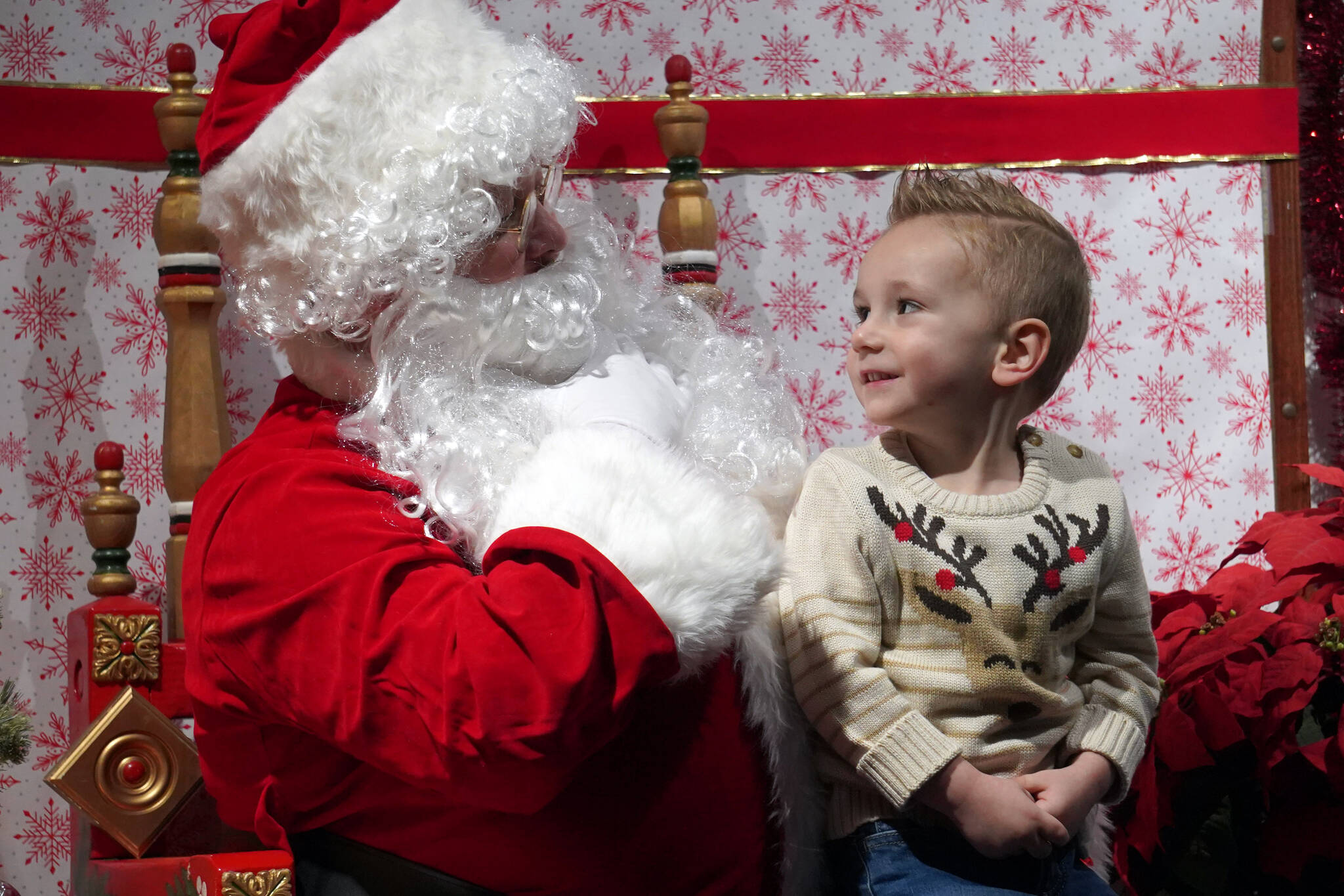 Santa Claus greets Hudson Reinhardt during Christmas Comes to Kenai festivities at the Kenai Chamber of Commerce and Visitor Center in Kenai, Alaska, on Friday, Nov. 24, 2023. (Jake Dye/Peninsula Clarion)