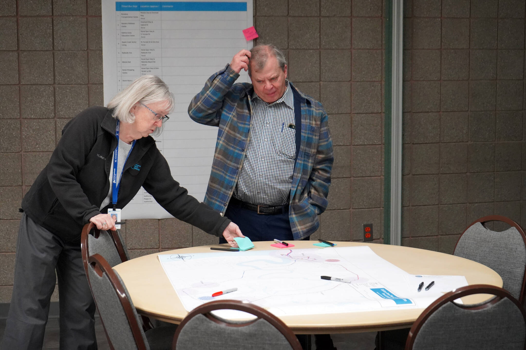 Kathy Gensel and Tim Navarre make suggestions on a preliminary route for the Kahtnu Area Transit at the Challenger Learning Center of Alaska in Kenai, Alaska, on Wednesday, Nov. 29, 2023. (Jake Dye/Peninsula Clarion)