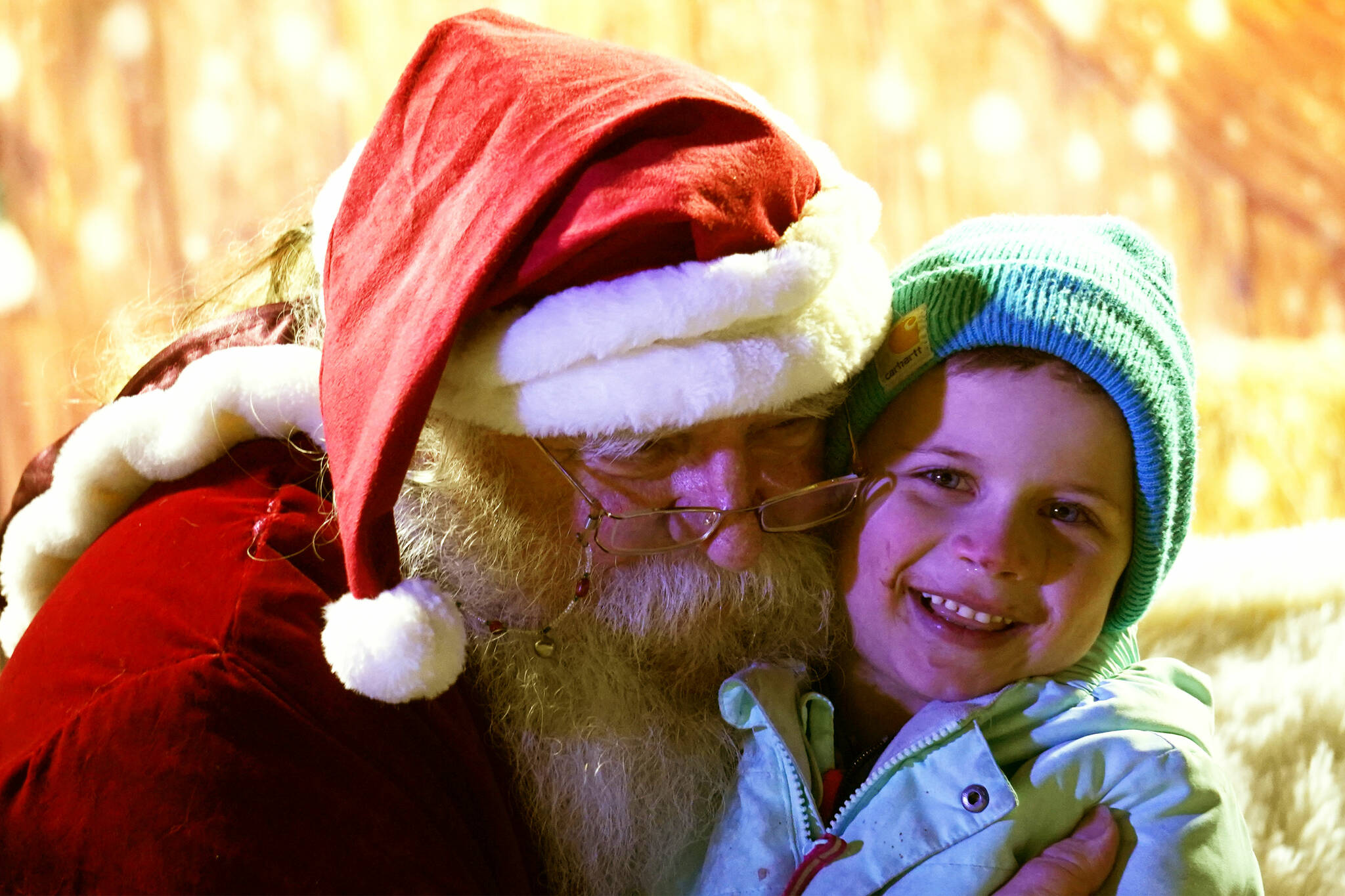 Santa Claus hugs Paul Cook during Christmas in the Park festivities at Soldotna Creek Park in Soldotna, Alaska, on Saturday, Dec. 2, 2023. (Jake Dye/Peninsula Clarion)