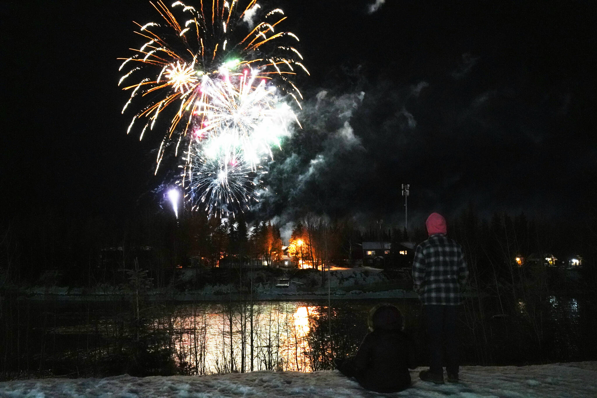 Lindsey, Cody and Lawson Farwell watch fireworks explode over the Kenai River during Christmas in the Park festivities at Soldotna Creek Park in Soldotna, Alaska, on Saturday, Dec. 2, 2023. (Jake Dye/Peninsula Clarion)